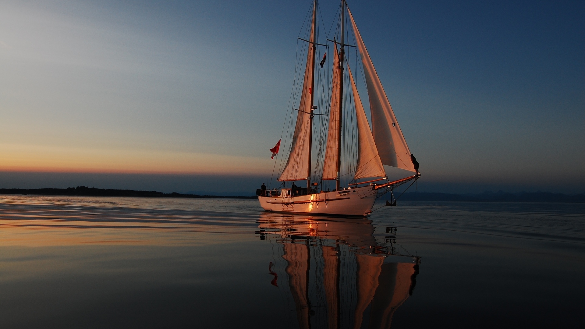 Большая парусная яхта в море на закате