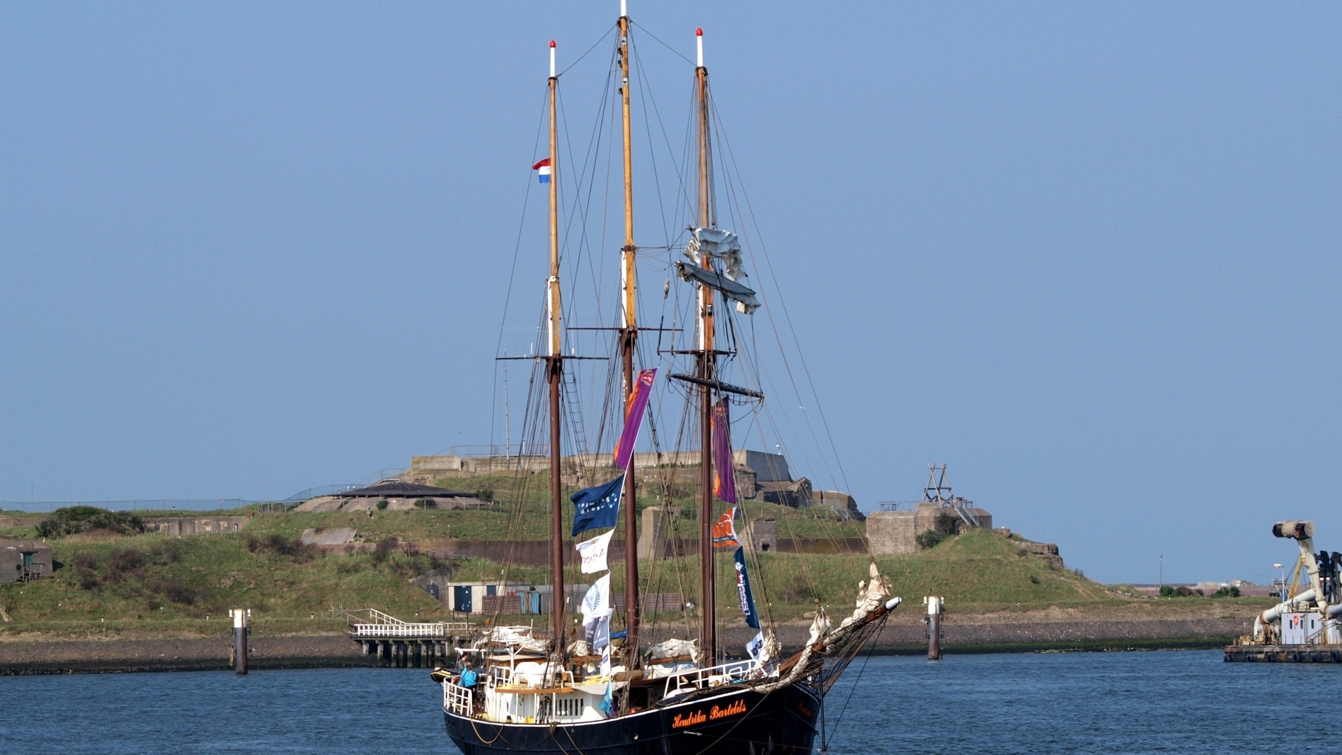 Большой корабль с опущенными парусами в гавани
