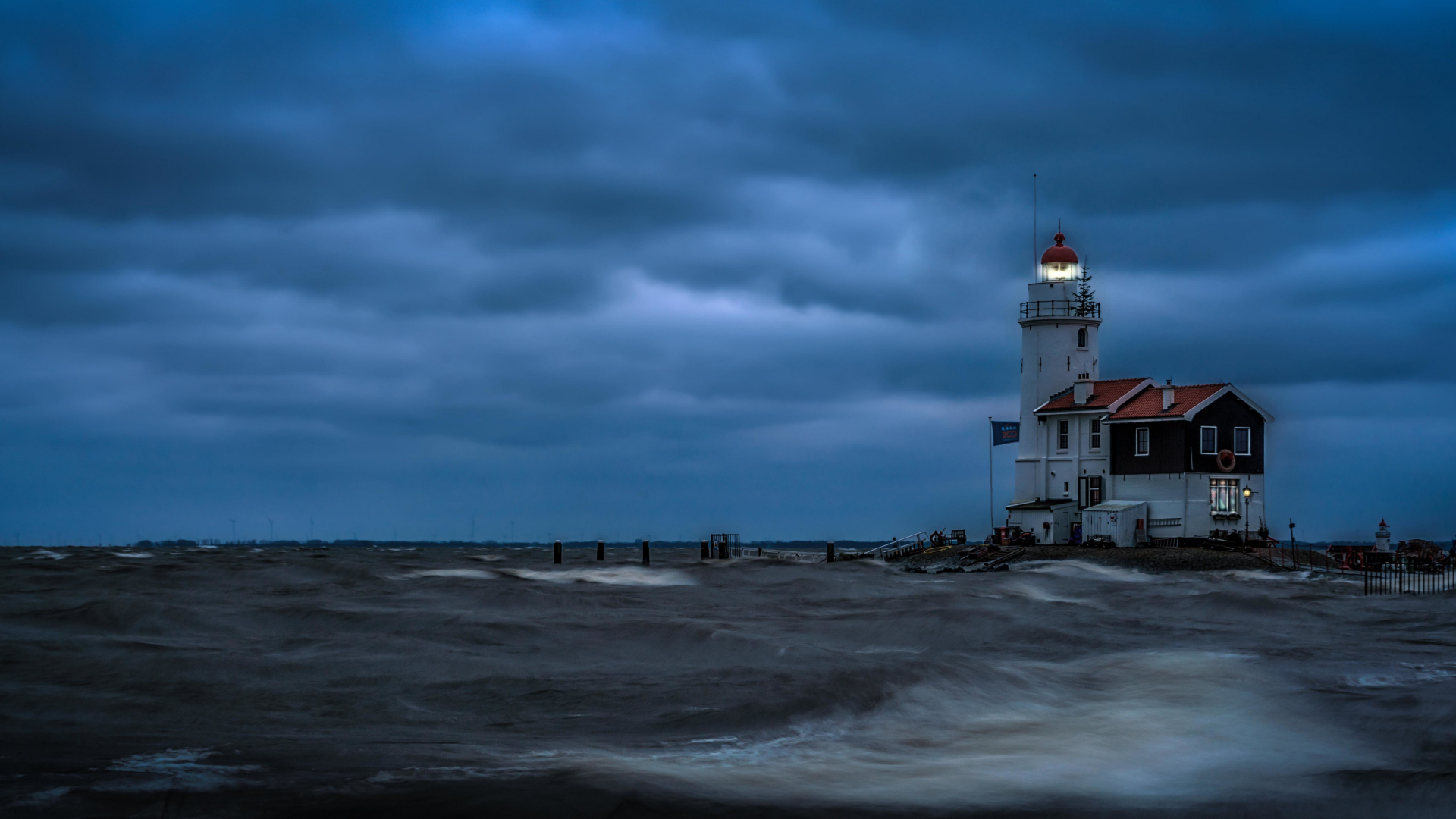 Маяк на морском побережье в сумерках, Голландия. Нидерланды