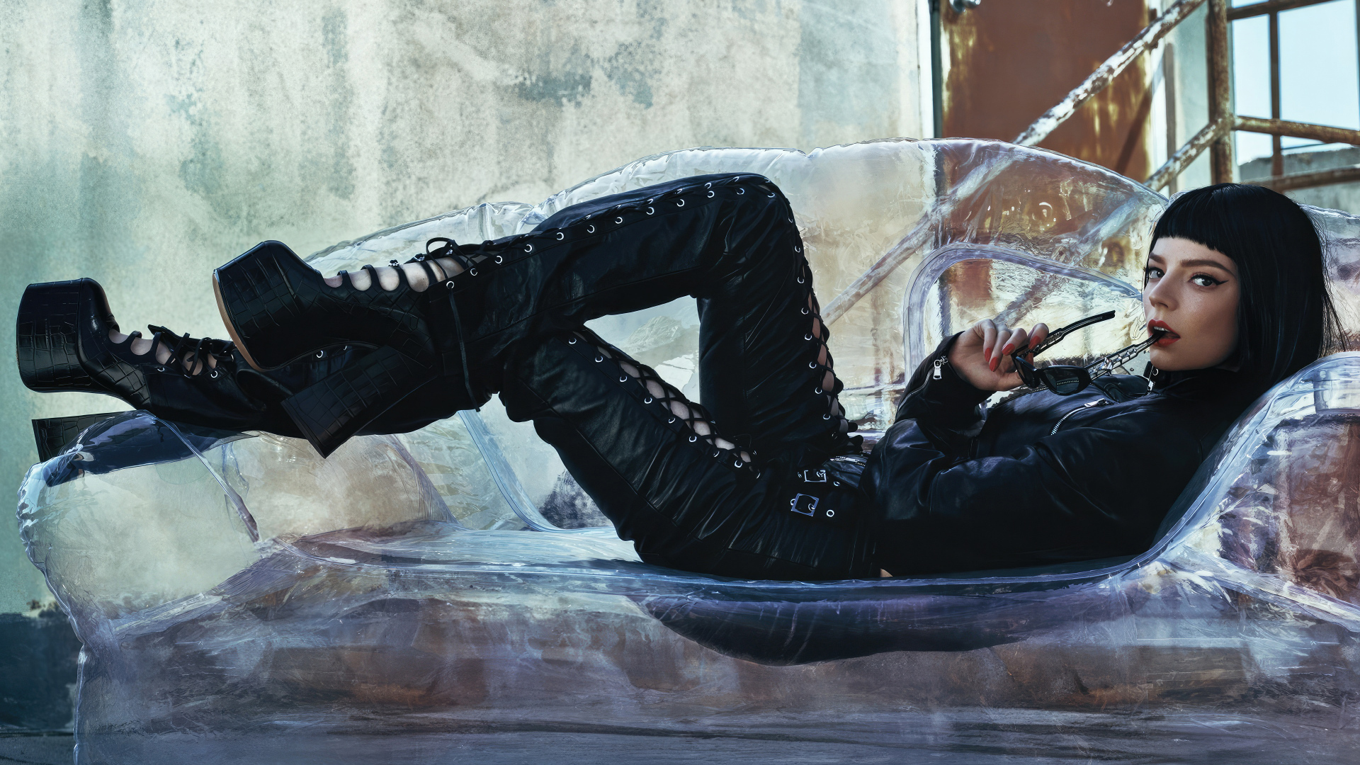 Актриса Аня Тейлор-Джой в черном костюме лежит на диване