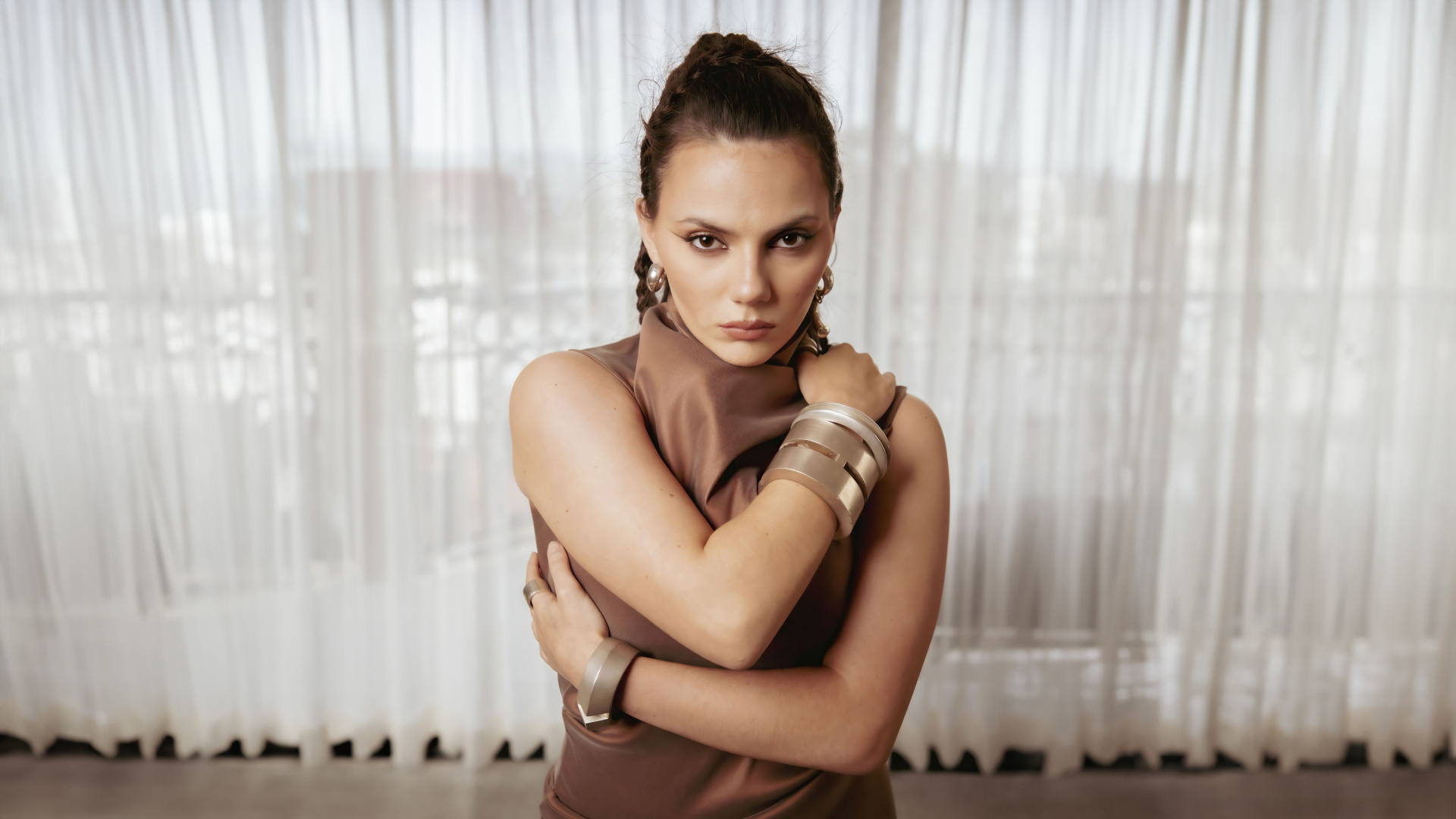 Актриса Дафни Кин с браслетами на руках у окна