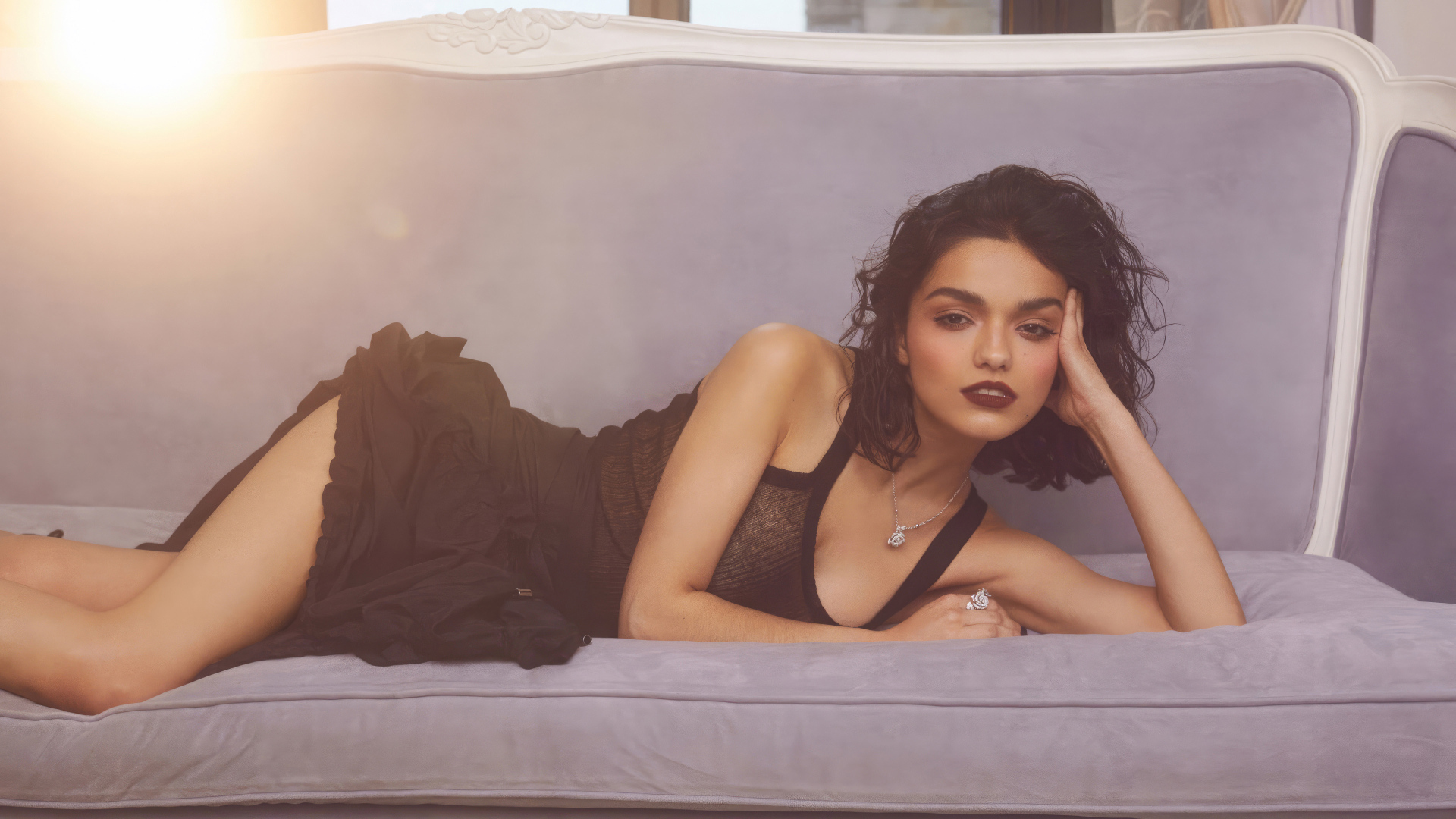 Актриса Рэйчел Зеглер в черном платье лежит на диване