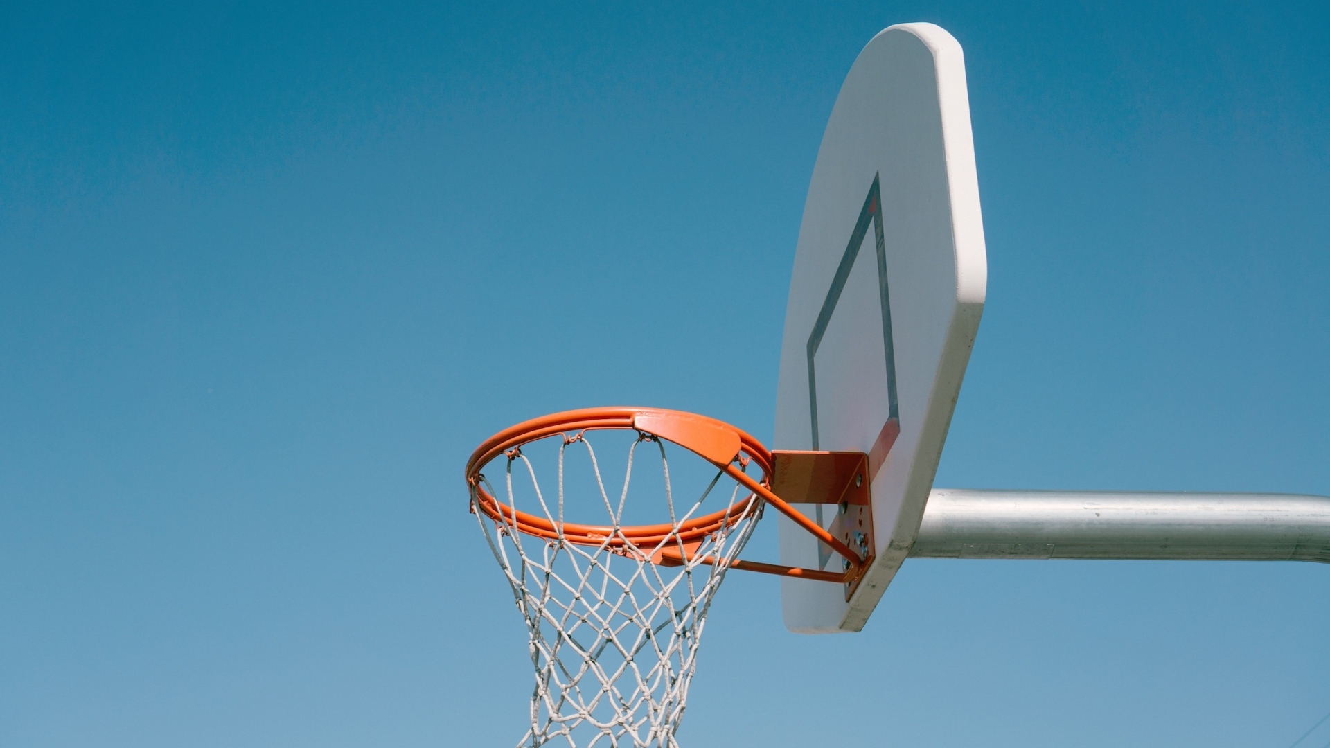 Кольцо для игры в баскетбол на фоне голубого неба