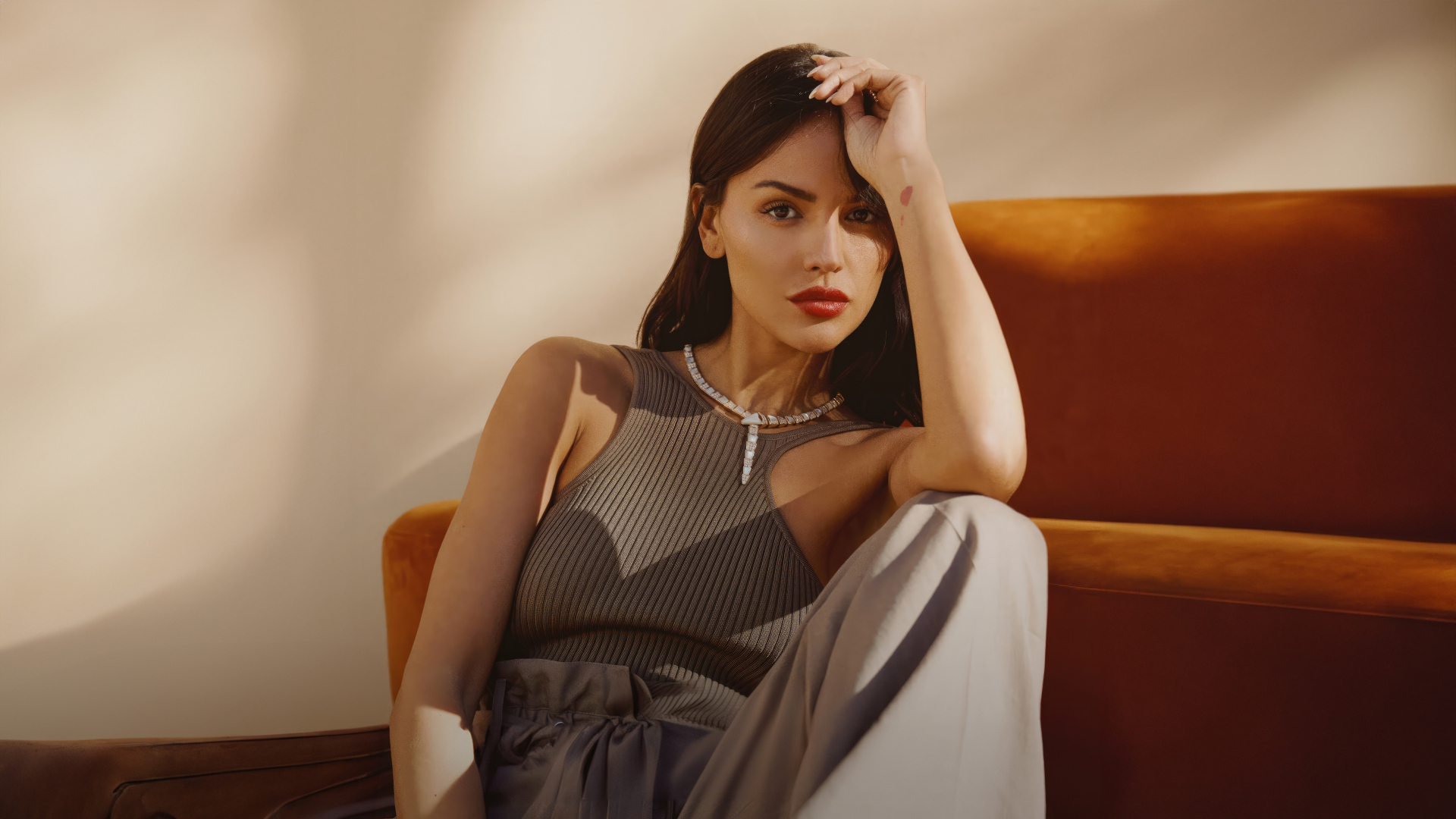 Красивая брюнетка, актриса Эйса Гонсалес сидит у дивана