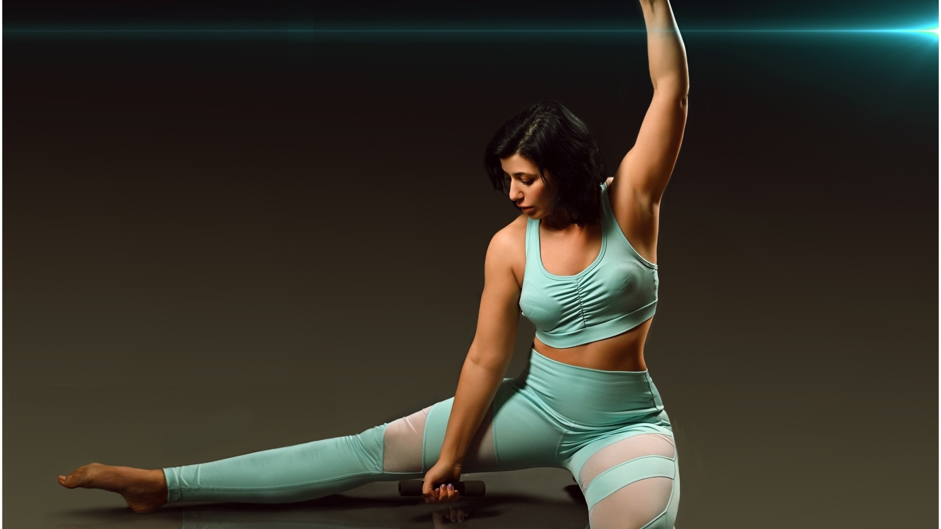 Девушка занимается фитнесом с гантелями