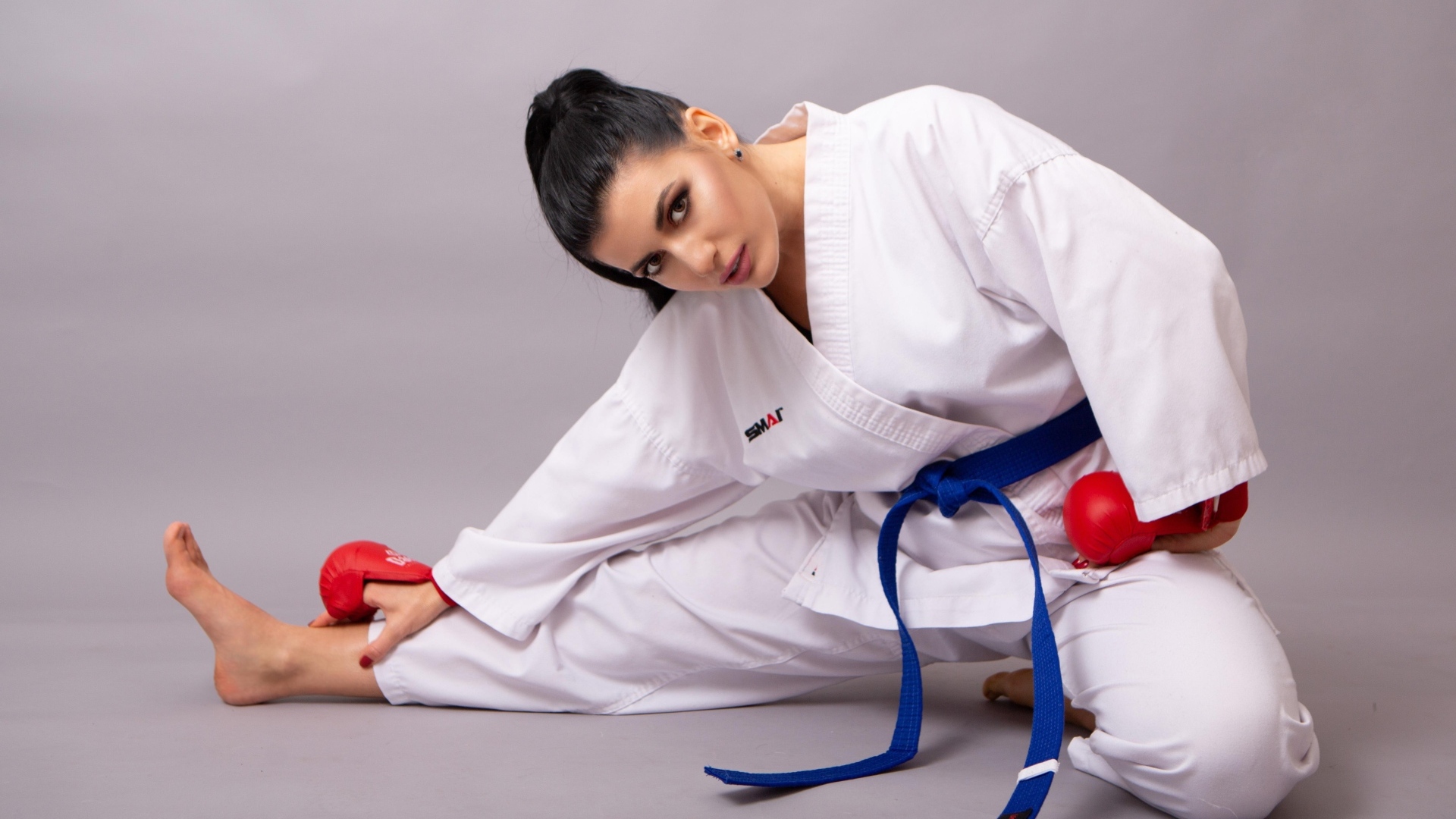 Девушка в белой спортивной форме на сером фоне