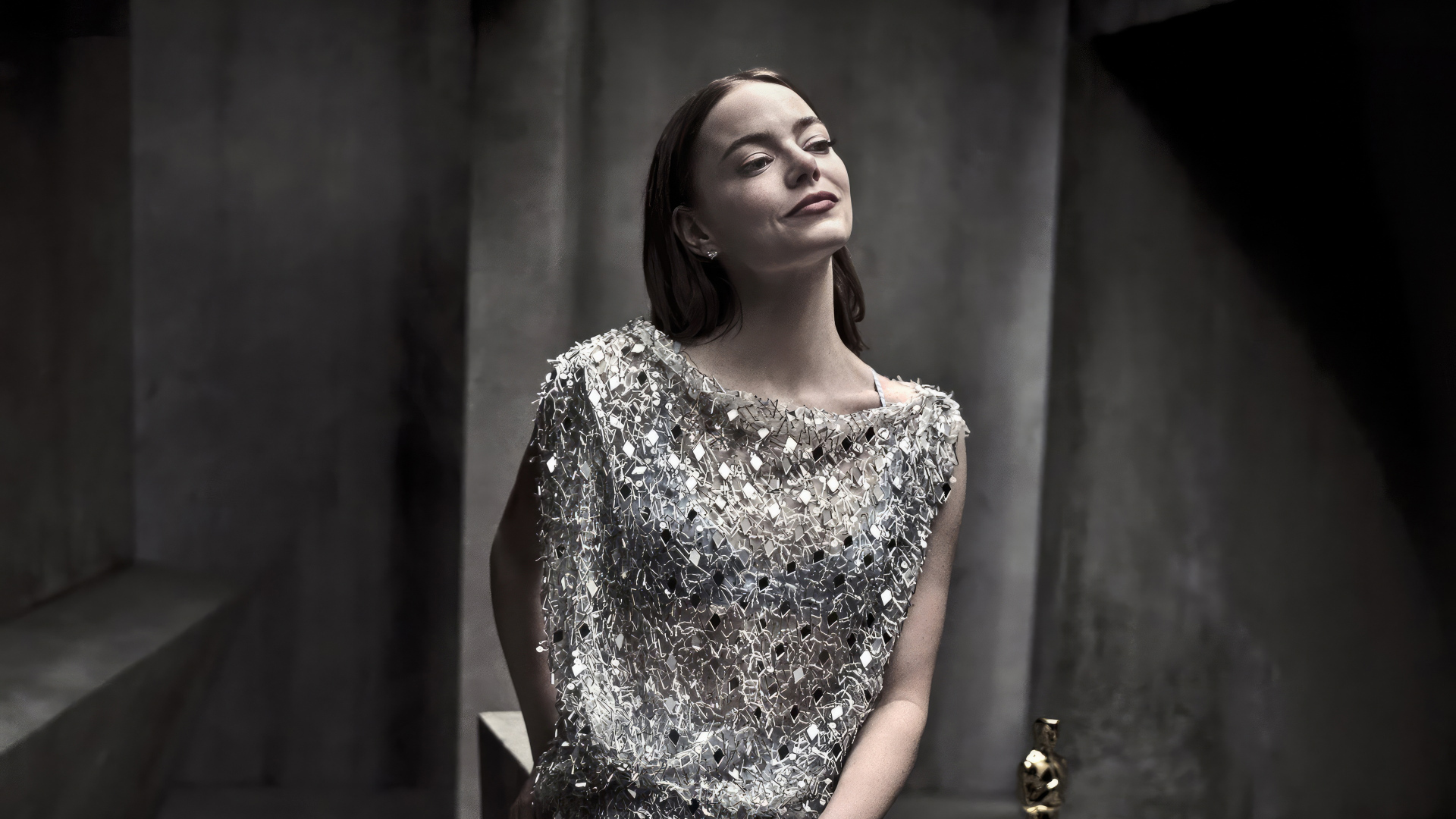 Рыжеволосая актриса Эмма Стоун в блестящем платье в серой комнате