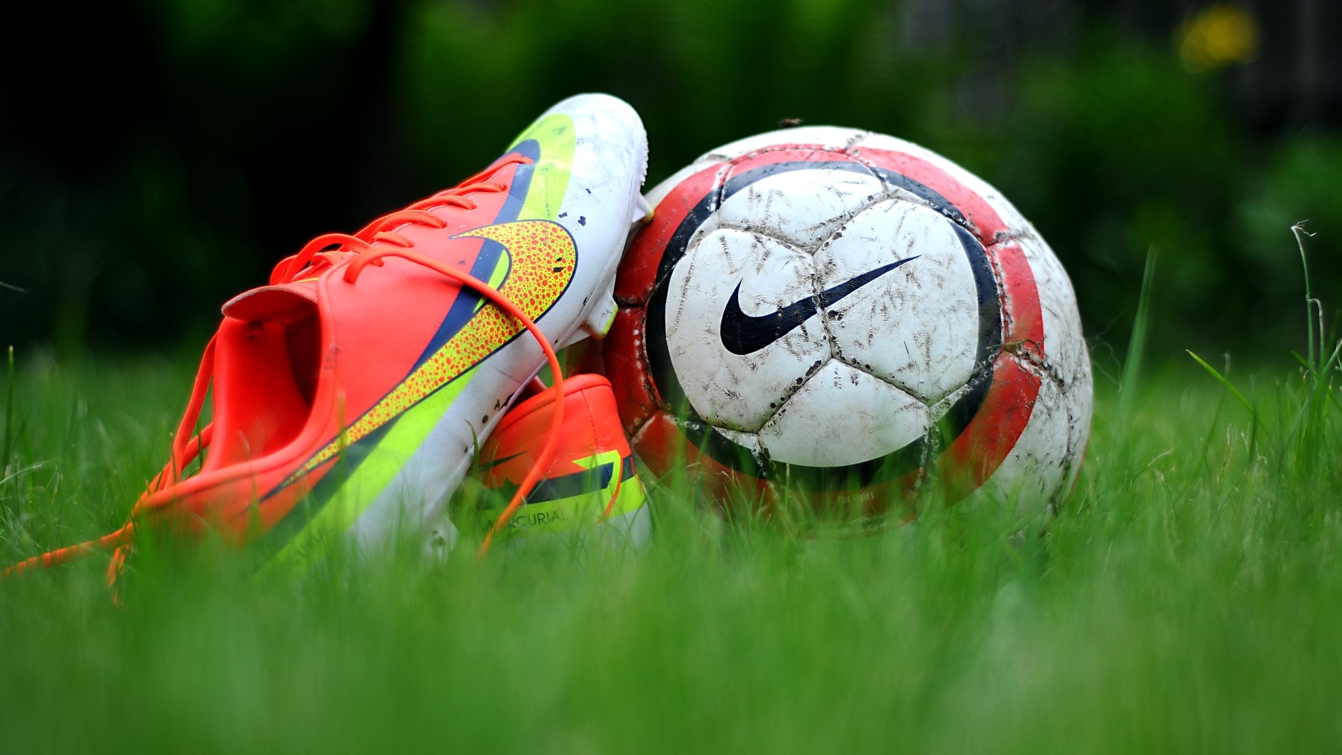 Футбольный мяч и бутсу на зеленой траве