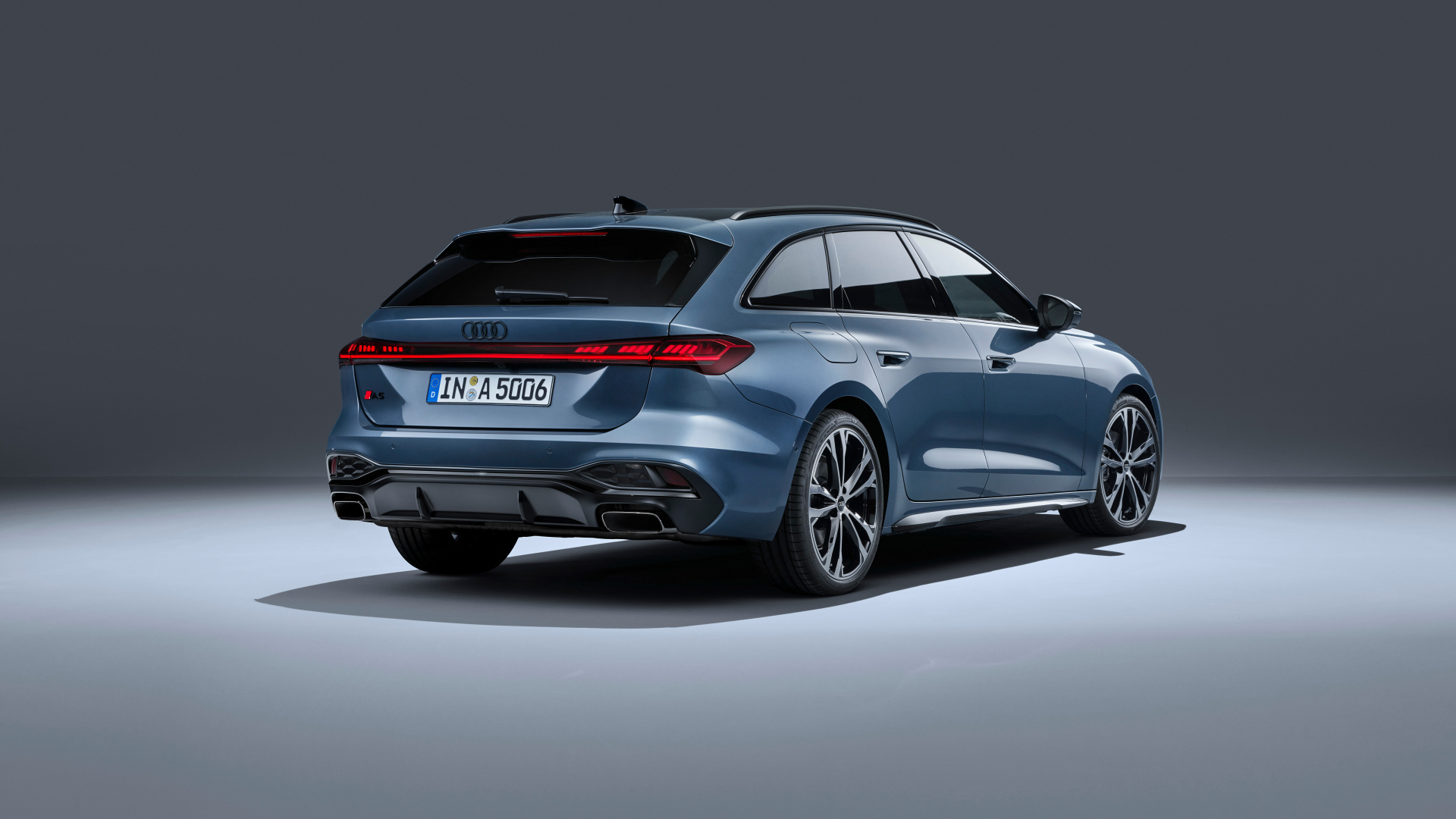 Вид сзади на автомобиль Audi A5 Avant TFSI quattro S line 2024 года на сером фоне