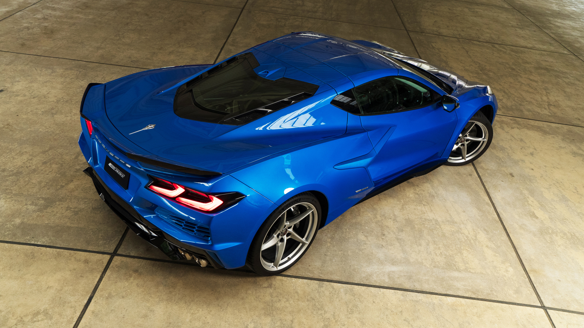 Вид сзади на синий автомобиль Chevrolet Corvette E-Ray 2024 года