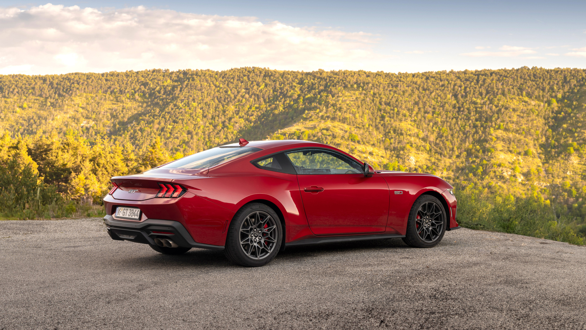 Красный автомобиль Ford Mustang GT 2024 года вид сзади