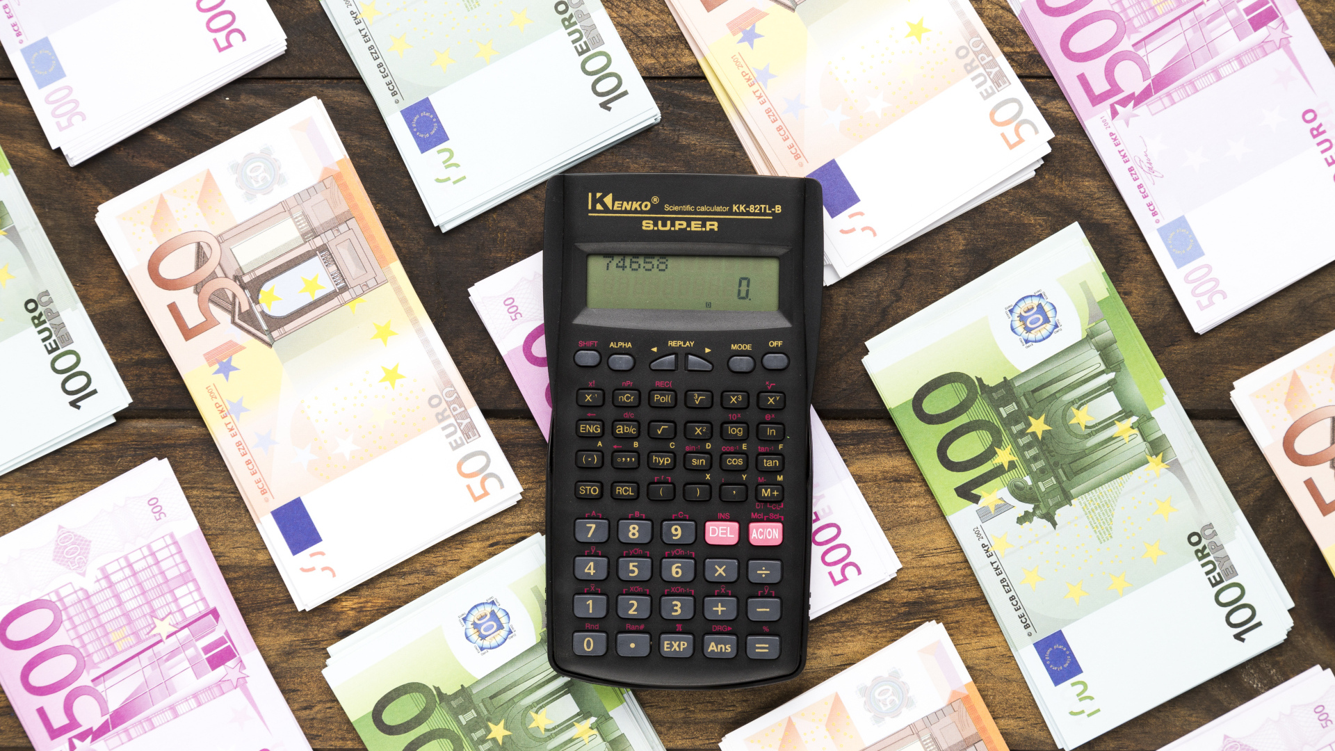 Калькулятор и купюры евро на деревянном столе