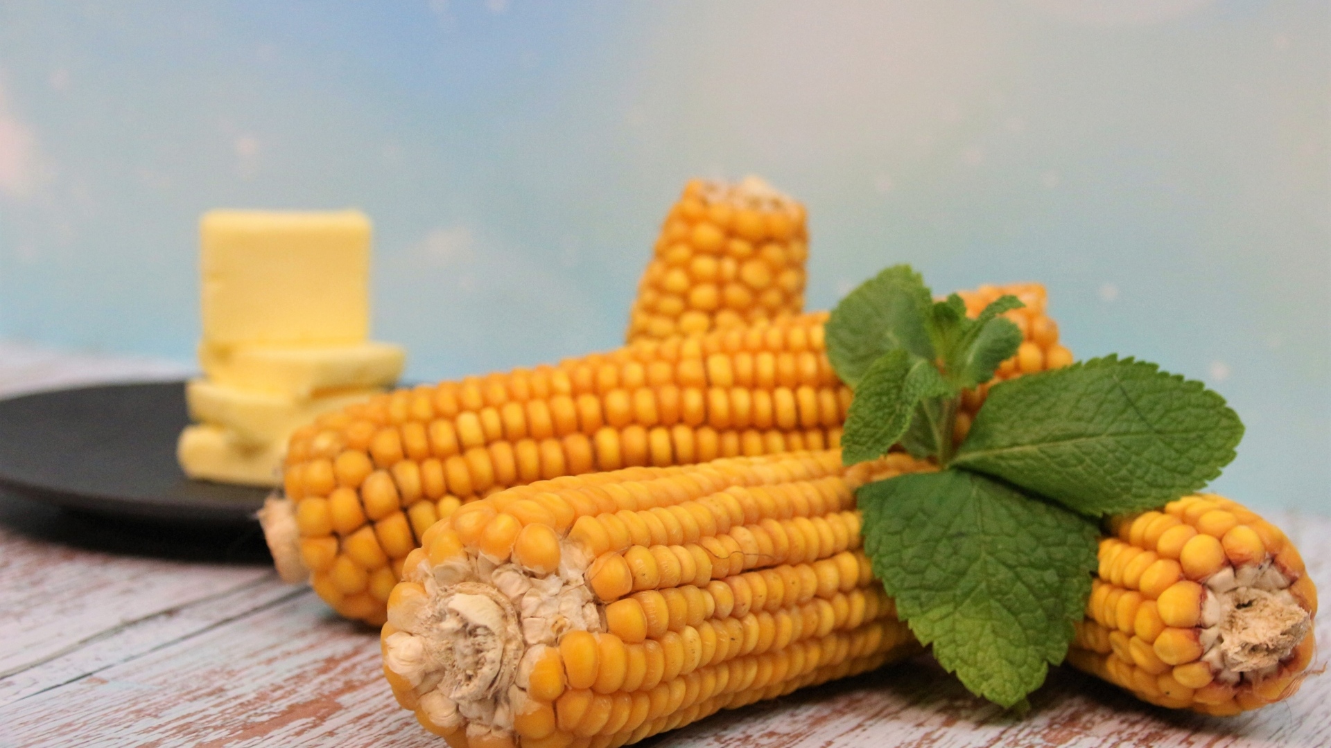 Початки кукурузы на столе с маслом