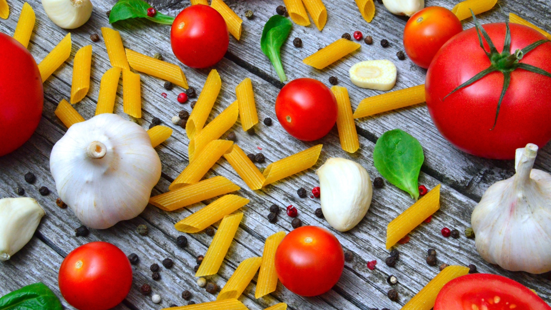 Макароны на столе с помидорами и чесноком