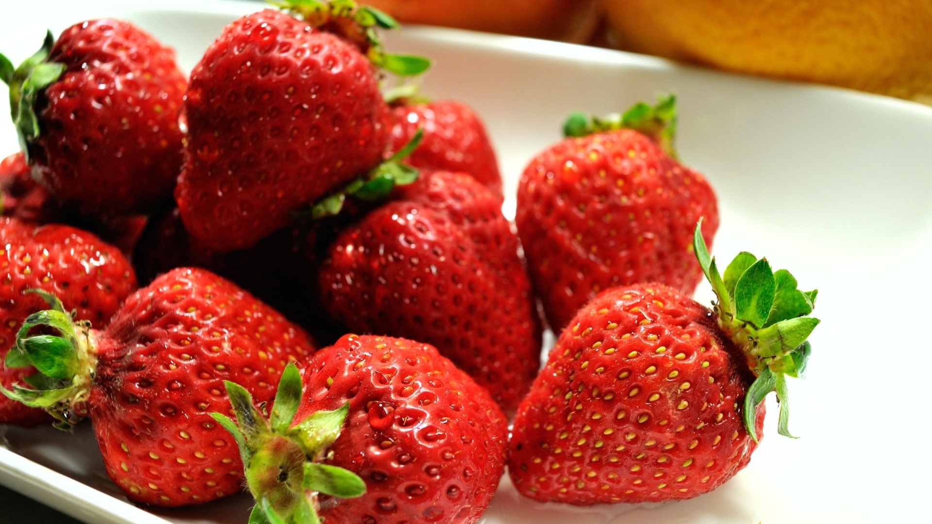 Ароматная красная клубника в белой тарелке