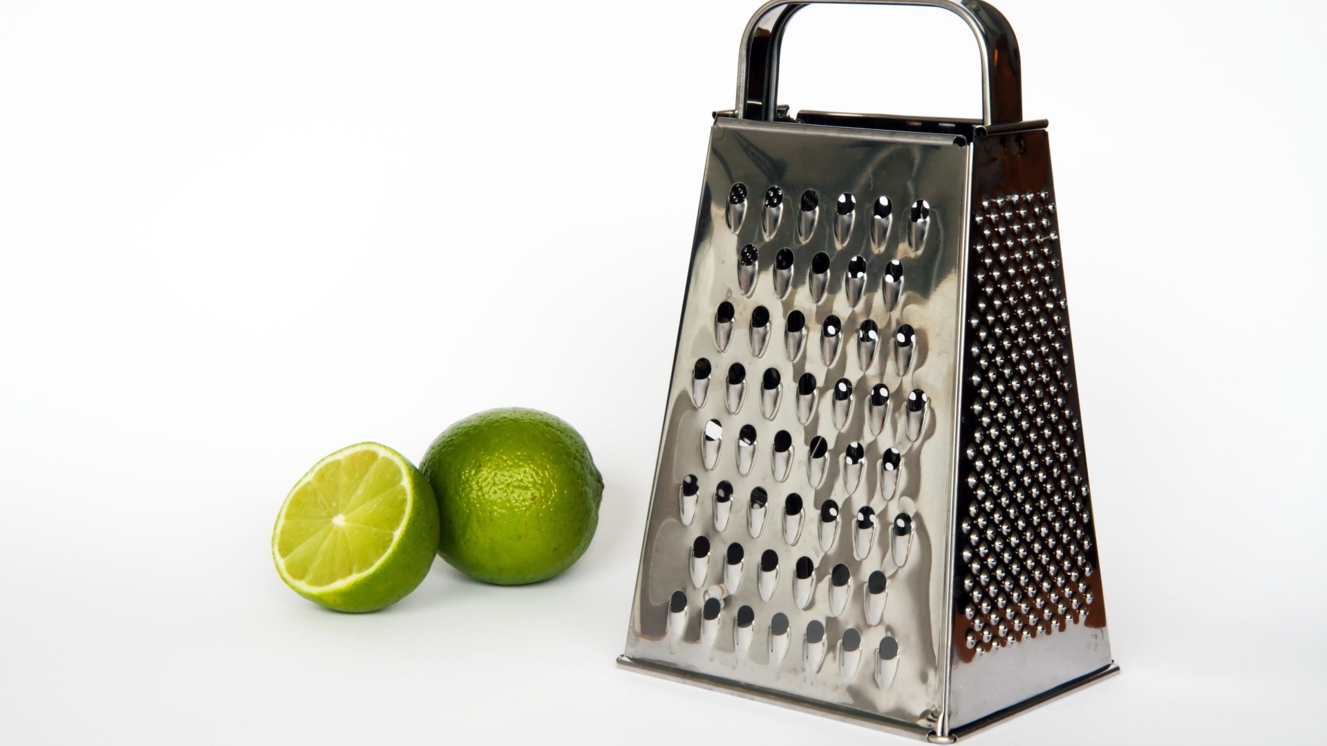 Терка с зеленым лаймом на сером фоне