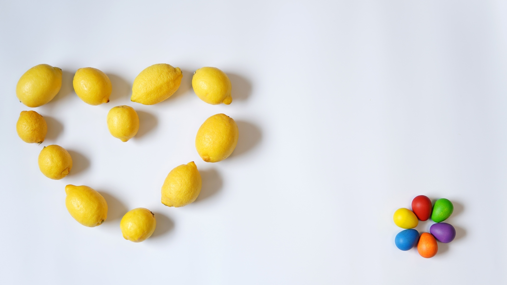 Сердце из желтых лимонов на сером фоне с конфетами