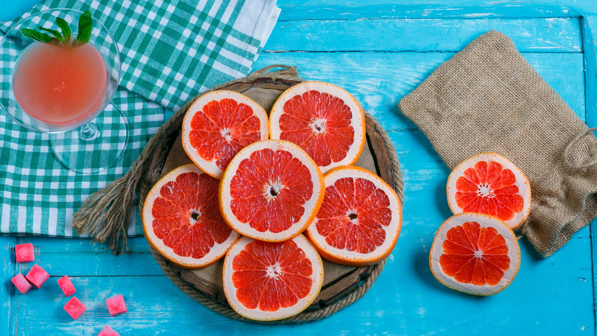 Нарезанный грейпфрут с соком на голубом столе