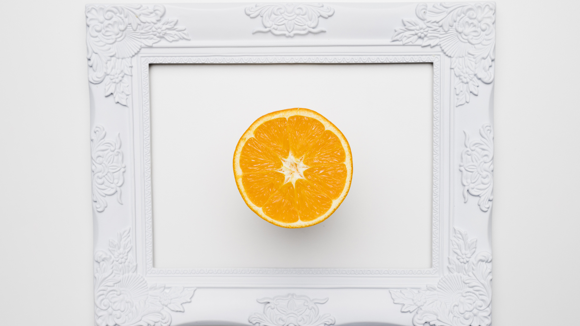 Белая рамка для фото с половиной апельсина