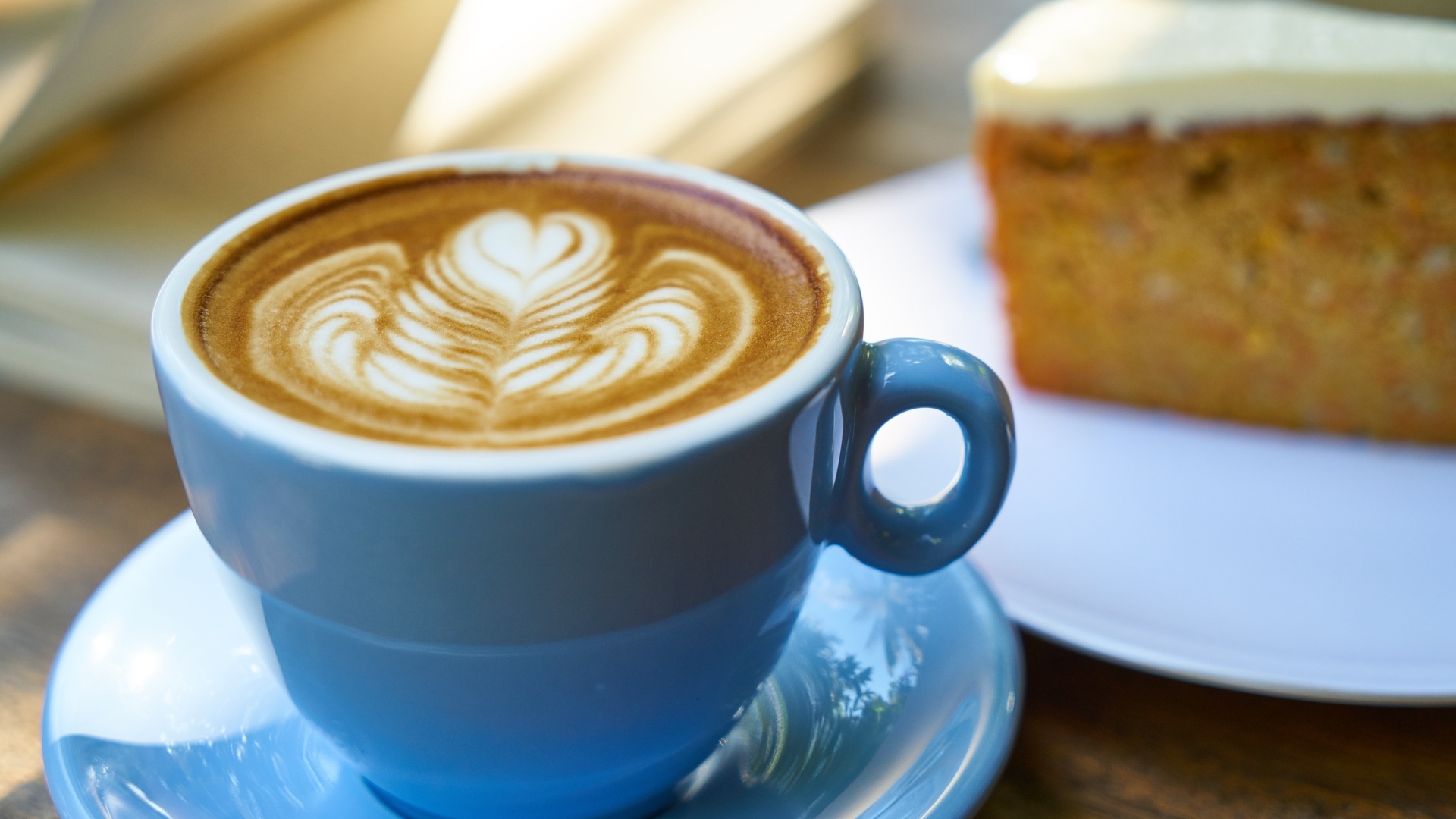 Чашка ароматного горячего кофе с рисунком на пене на столе на завтрак