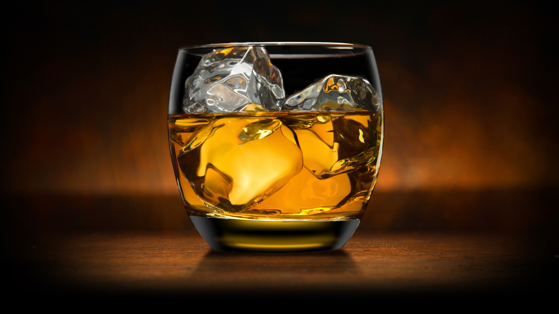 Стакан виски со льдом на столе