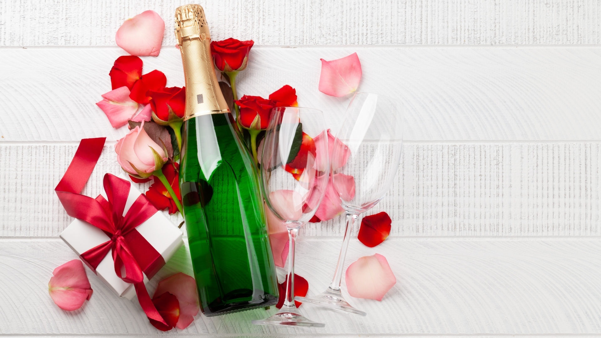Бутылка шампанского с цветами розы и подарком