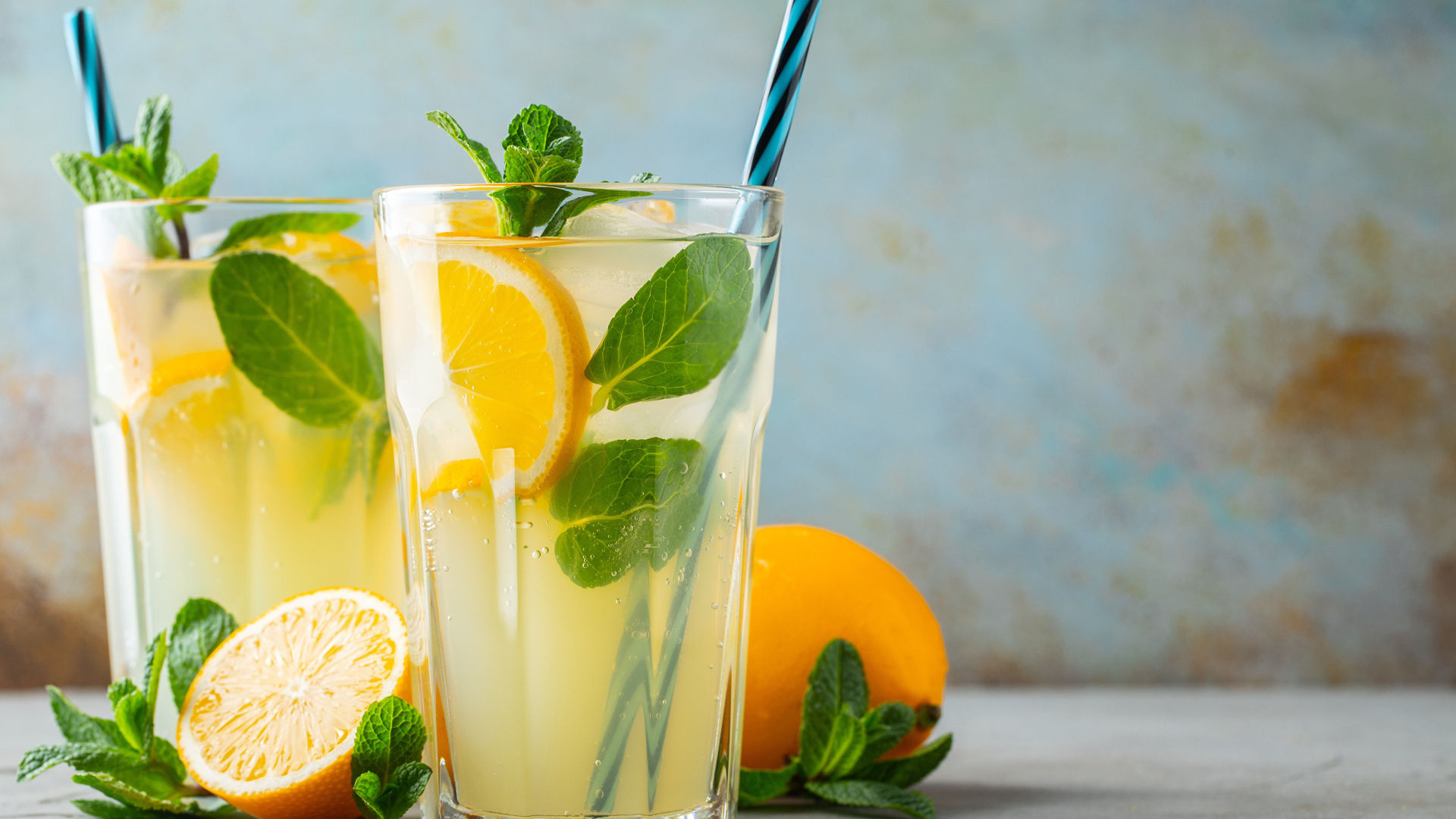 Два стакана лимонада на столе с лимоном