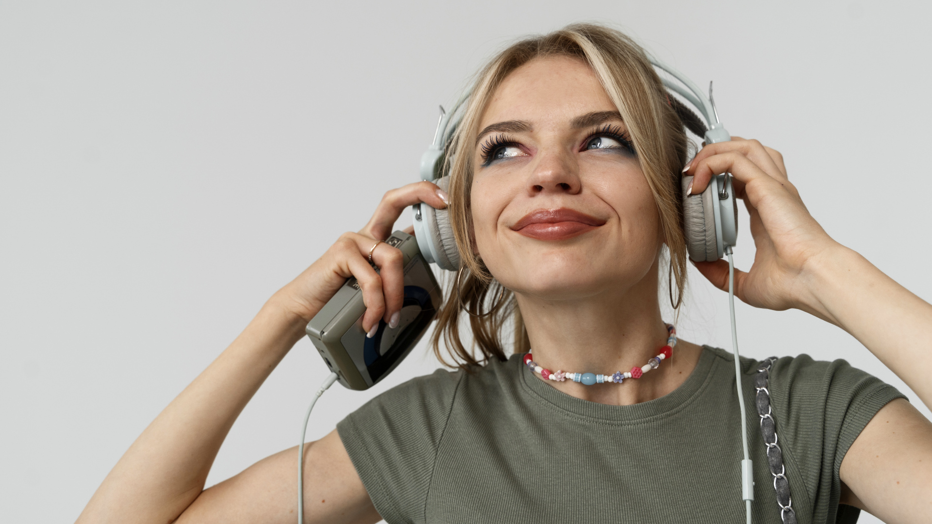 Красивая девушка в наушниках с плеером