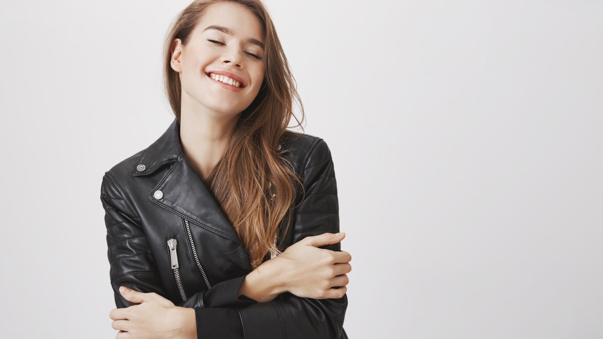 Девушка в черной кожаной куртке с закрытыми глазами