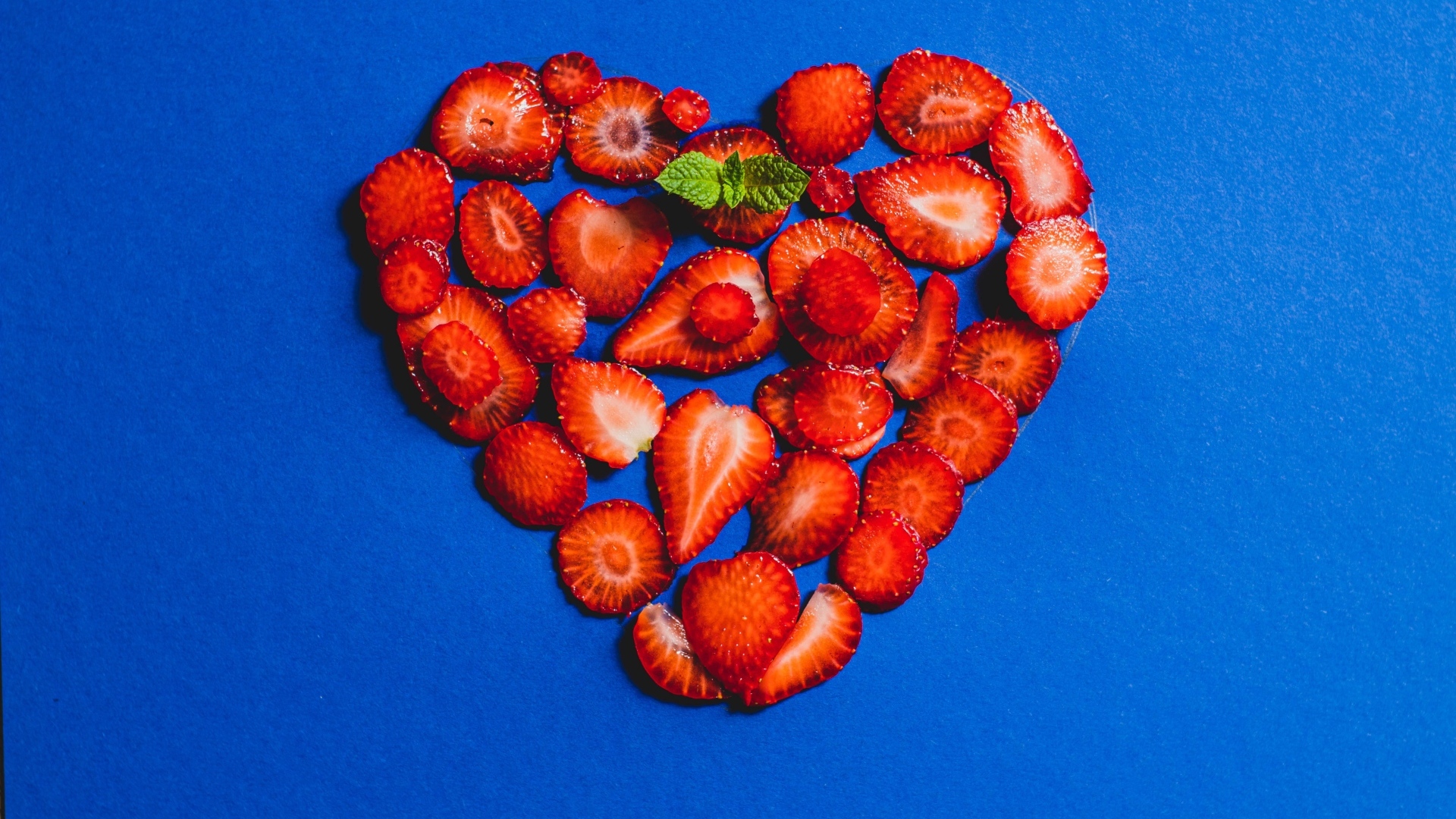 Сердце из сушеной клубники на синем фоне