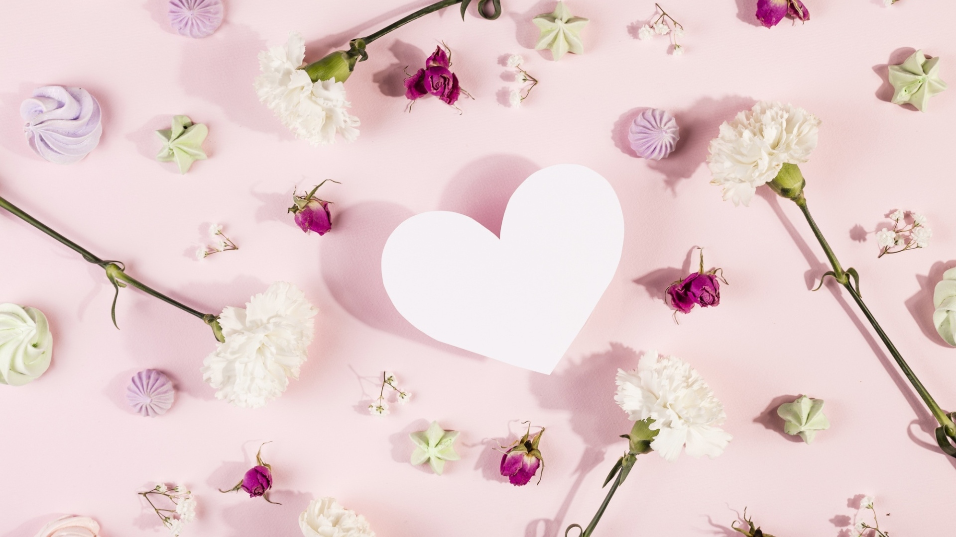 Белое бумажное сердце на розовом фоне с цветами