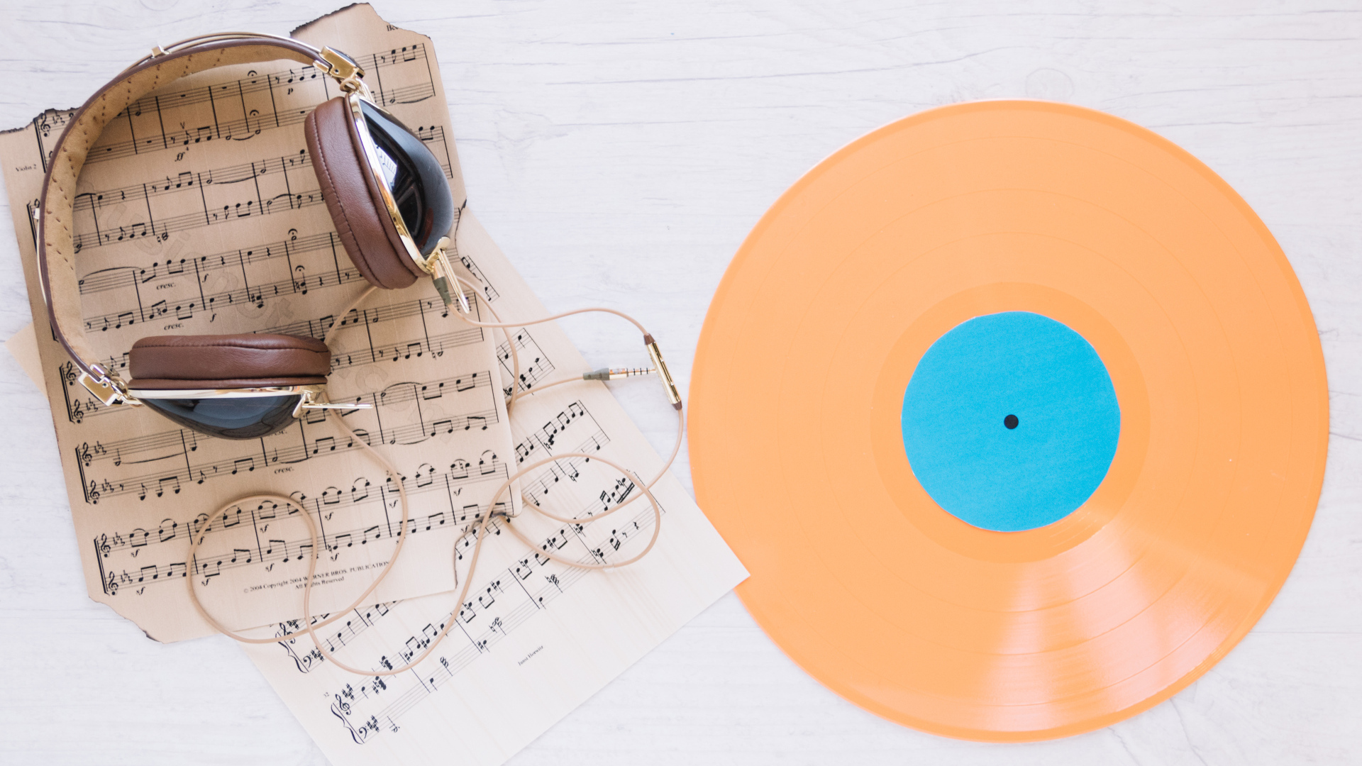 Наушники, ноты и виниловая пластинка на белом фоне