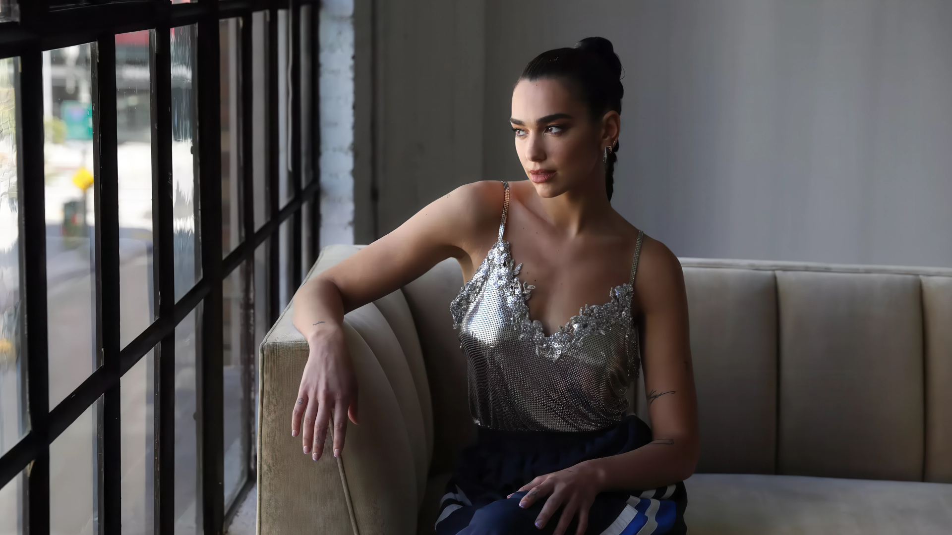 Певица Дуа Липа сидит у окна