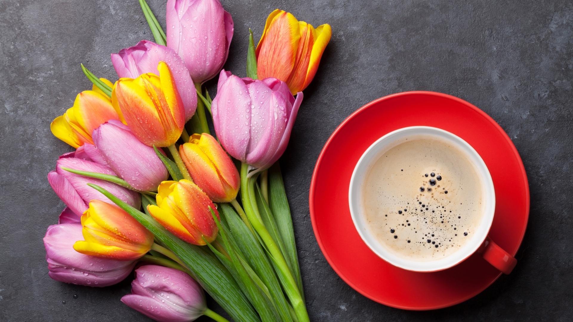 Букет разноцветных весенних тюльпанов на столе с чашкой кофе