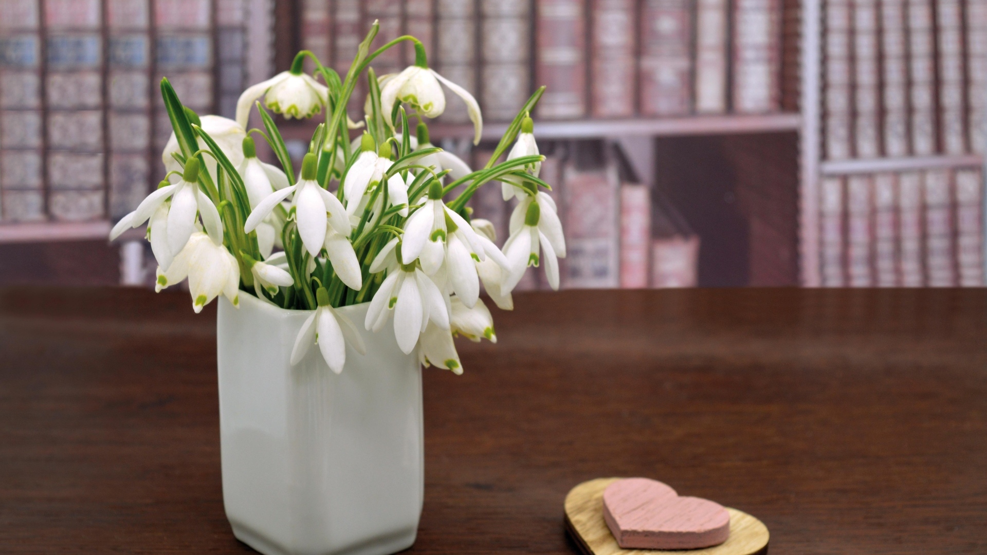 Букет белых подснежников в вазе на столе с сердечками