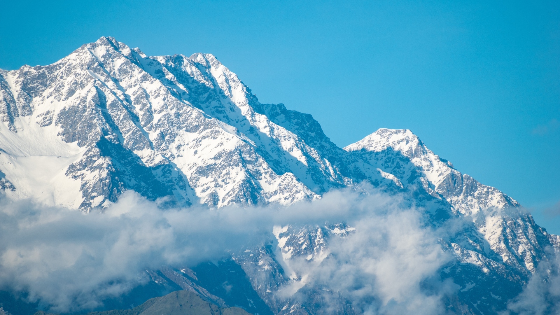 Высокие покрытые снегом горы на фоне голубого неба