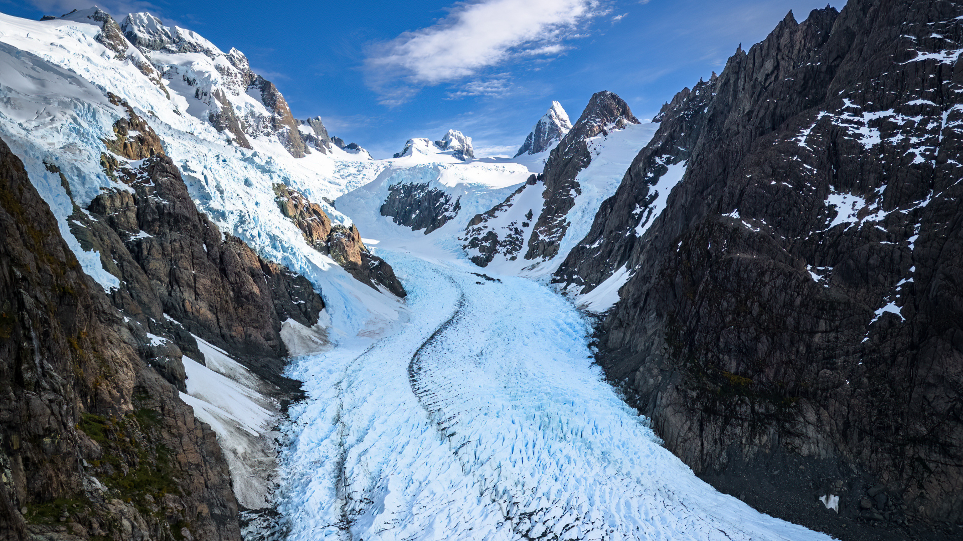 Заснеженная заледеневшая дорога между гор