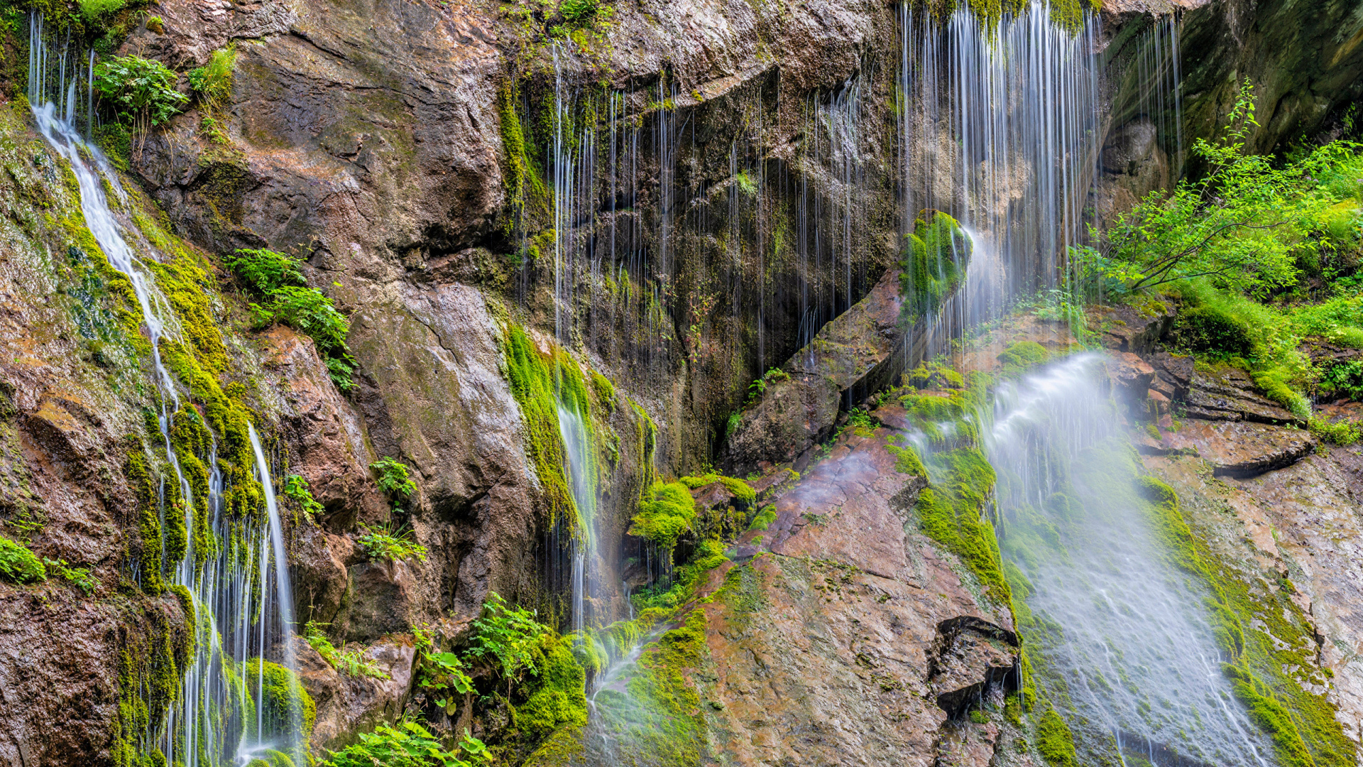Водопад стекает по большим холодным камнях