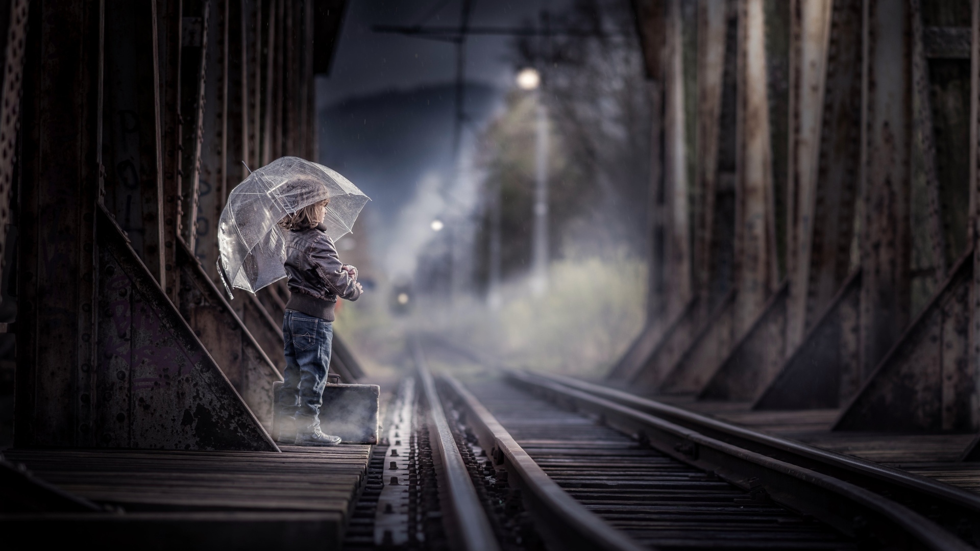 Ребенок под зонтом у железной дороги