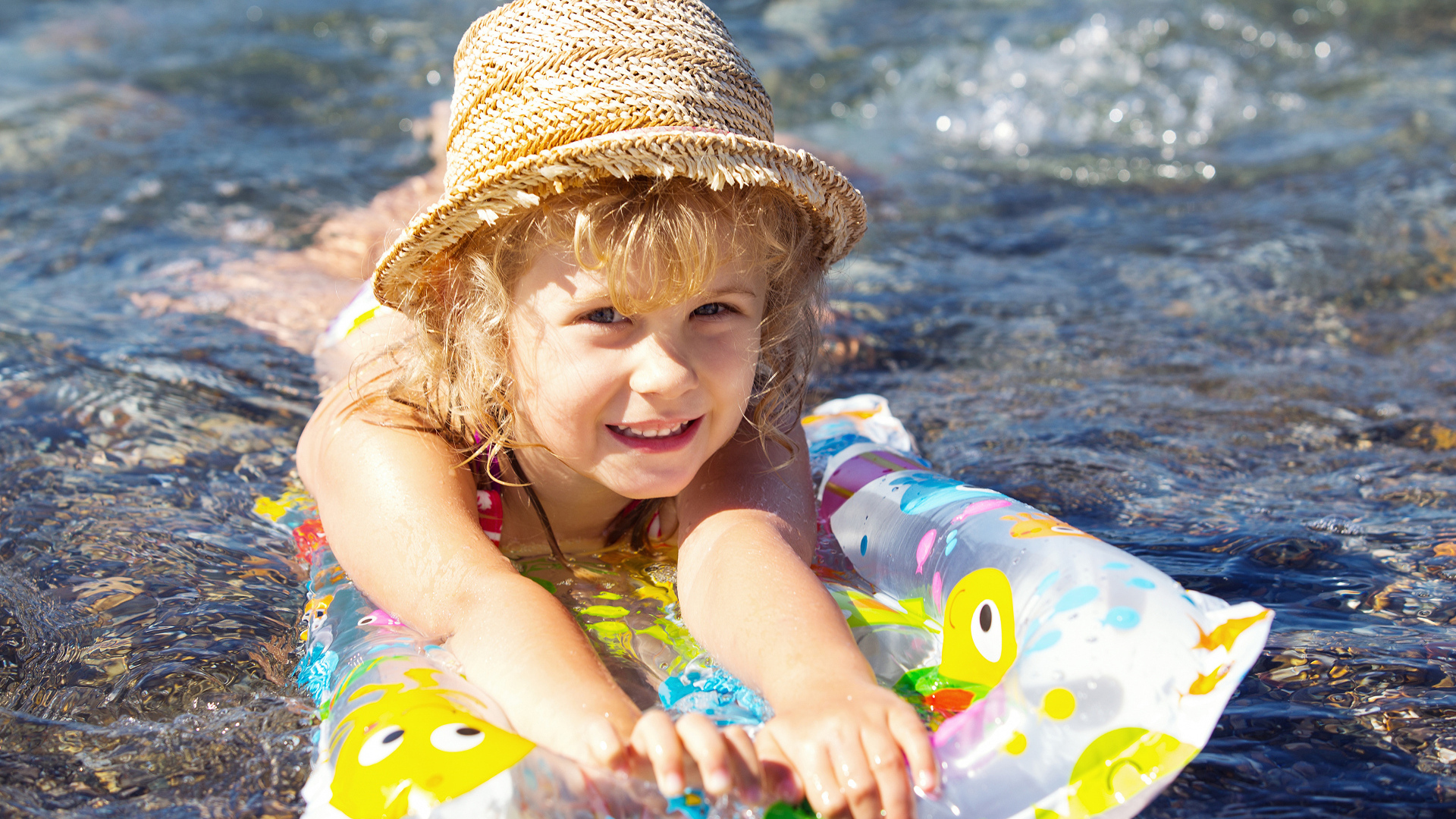 Девочка в шляпе плавает в воде
