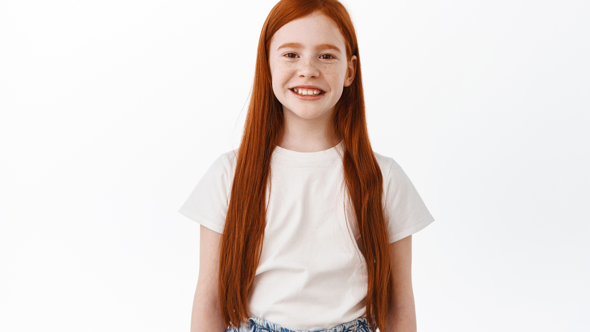 Улыбающаяся рыжеволосая девочка на белом фоне