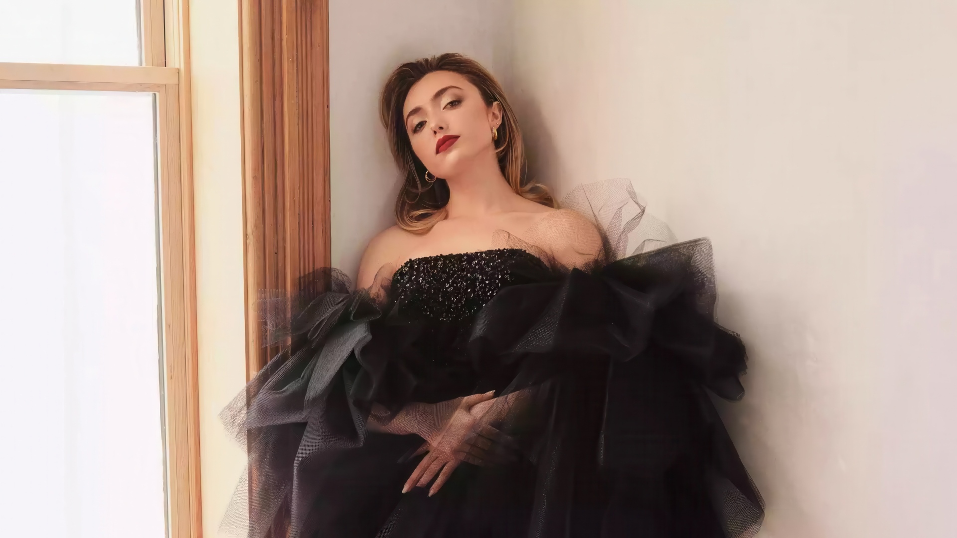 Актриса Пейтон Рой Лист в черном платье стоит у стены