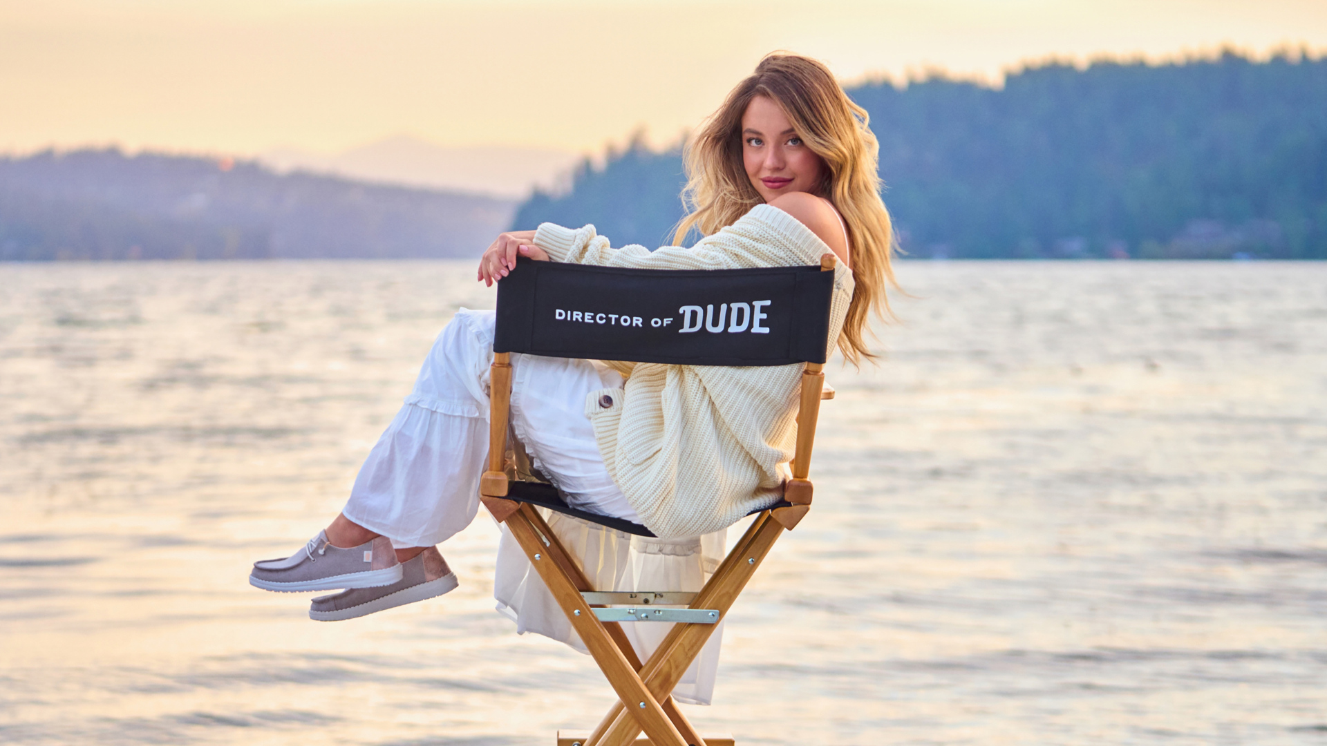 Актриса Сидни Суини сидит на стуле у озера