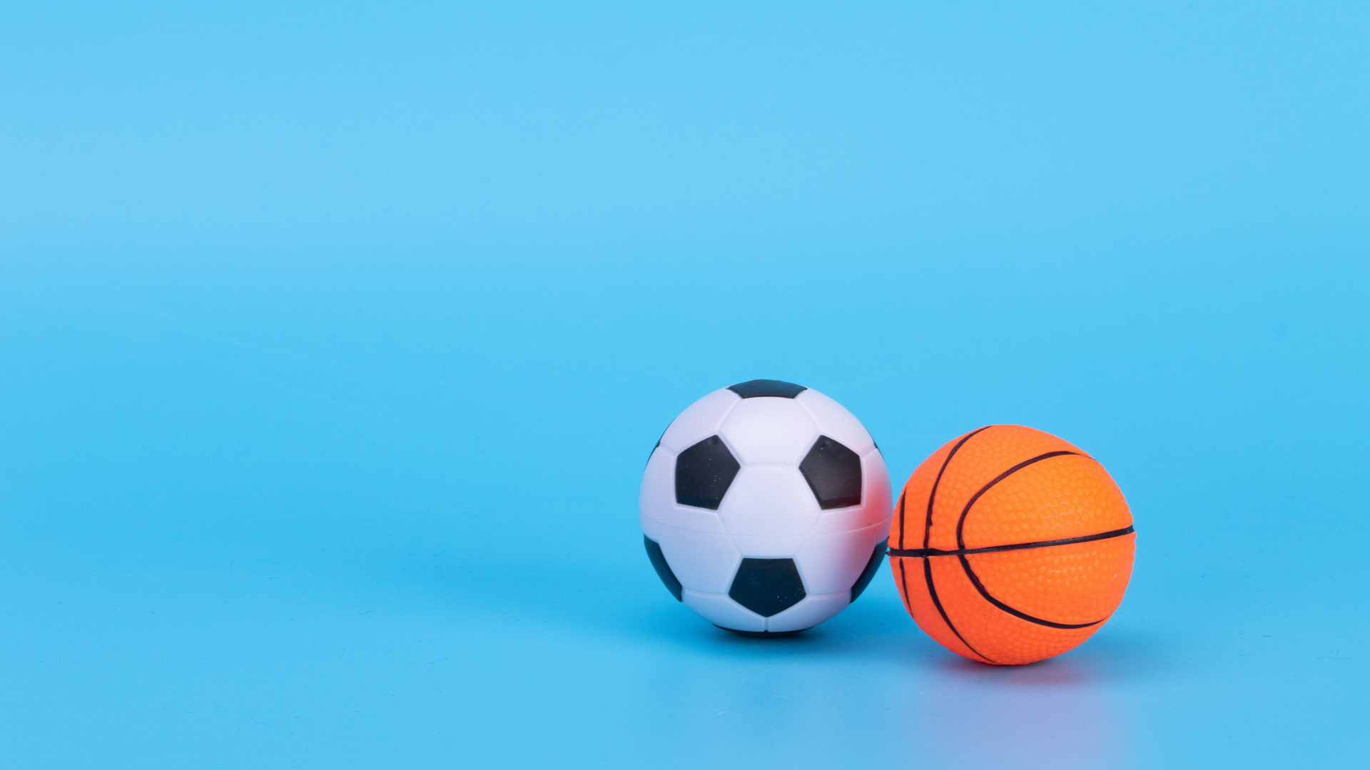Футбольный и баскетбольный мяч на голубом фоне