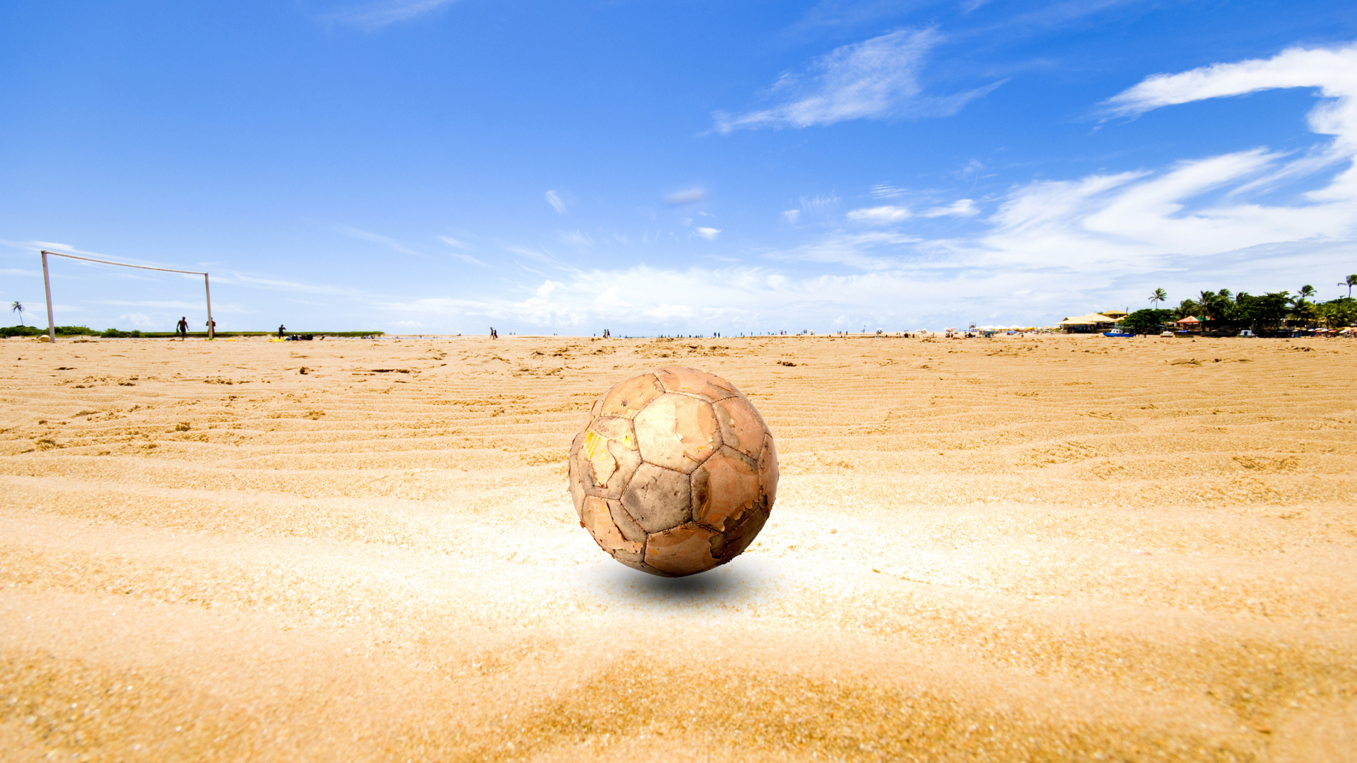 Старый футбольный мяч на песке