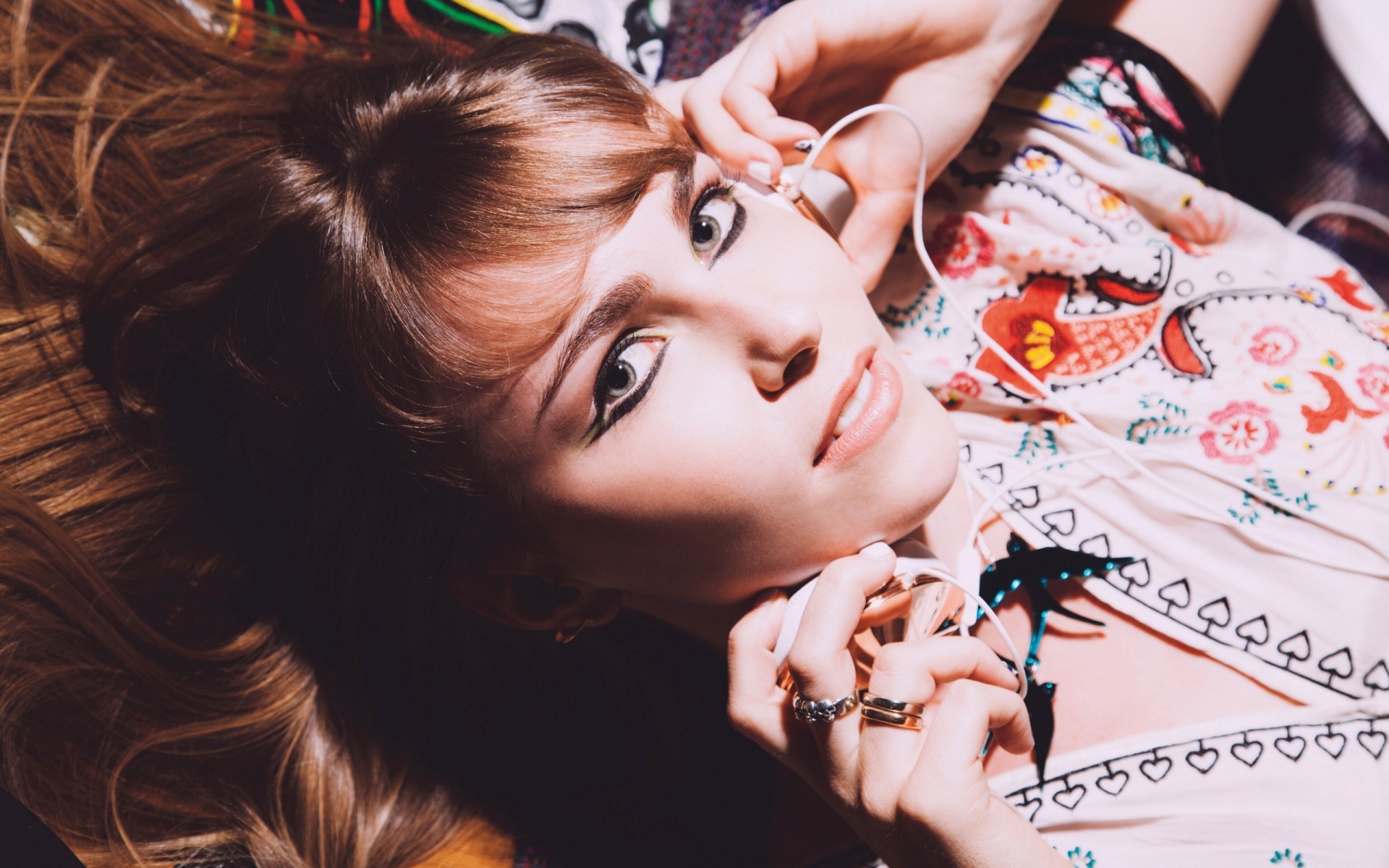 Девушка лежит с наушниками