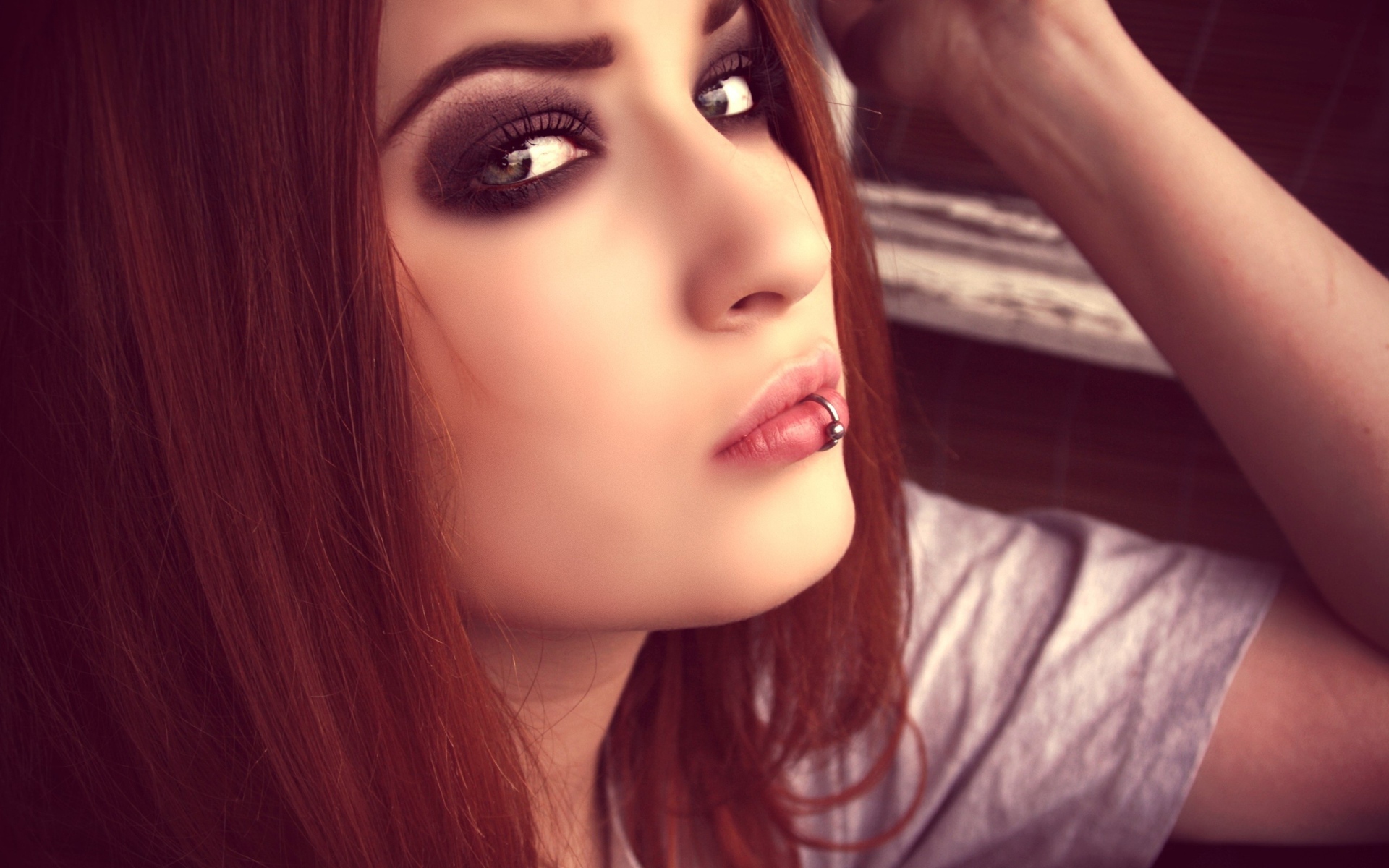 Молодая девушка шатенка с пирсингом в губе