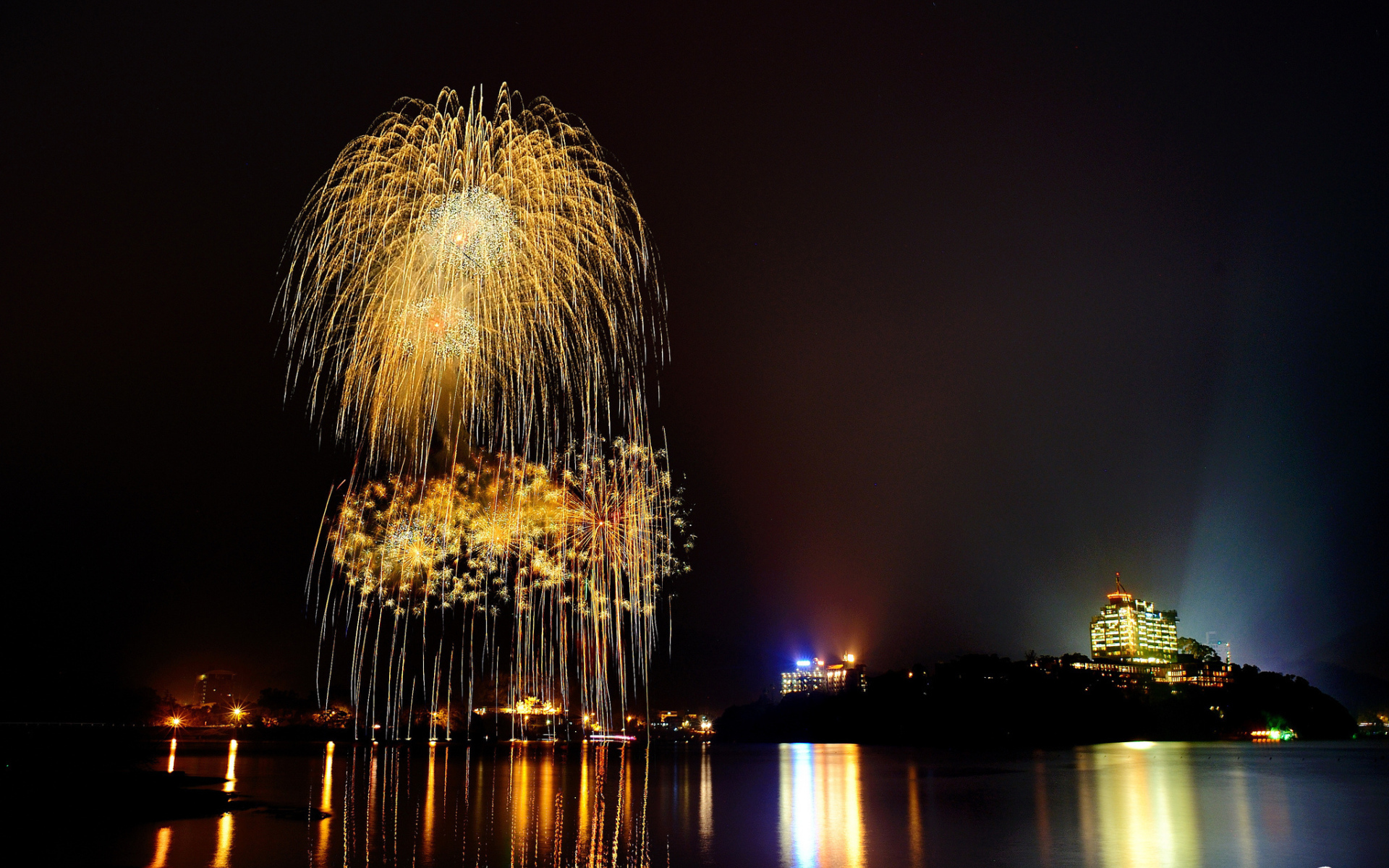 Праздничный фейерверк отражается в воде