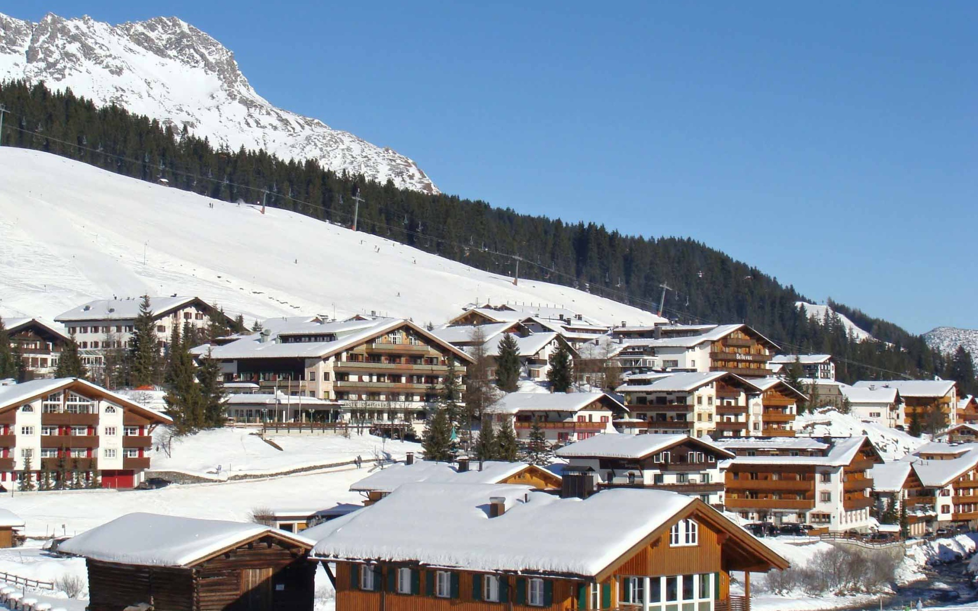 Дома на фоне гор на горнолыжном курорте Лех, Австрия