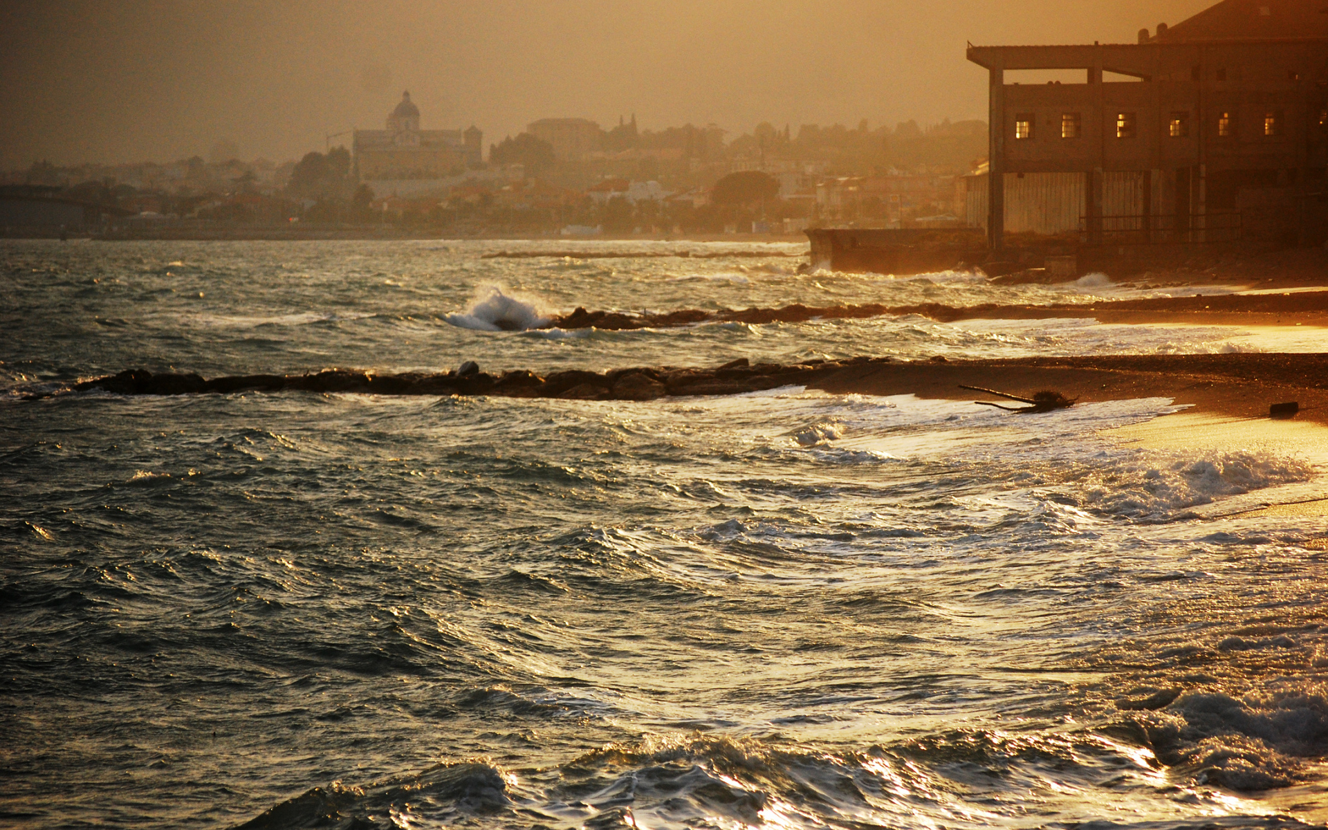 Закат на пляже на курорте в Пьетра Лигуре, Италия